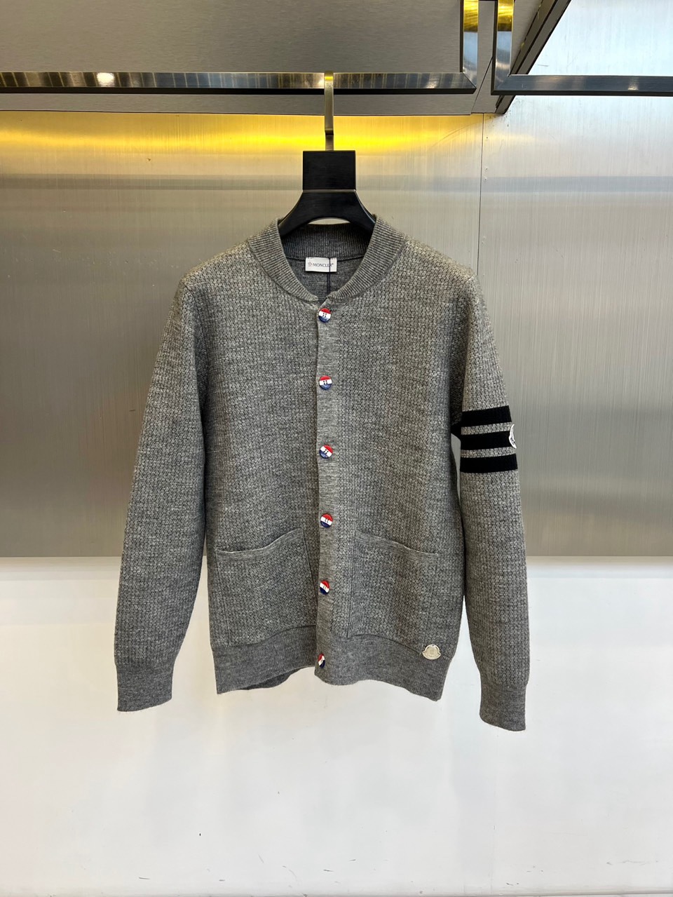🌾蒙口、2025秋冬新品以经典灰色针织开衫诠释休闲奢雅。标志性的棒球领设计，兼具利落与活力。前襟整齐排列