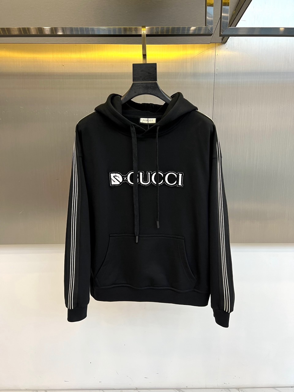 🌾Gucc古驰、2025秋冬系列以一款黑色连帽卫衣诠释经典新生。选用百搭黑色底蕴，搭配醒目白色“GUCC