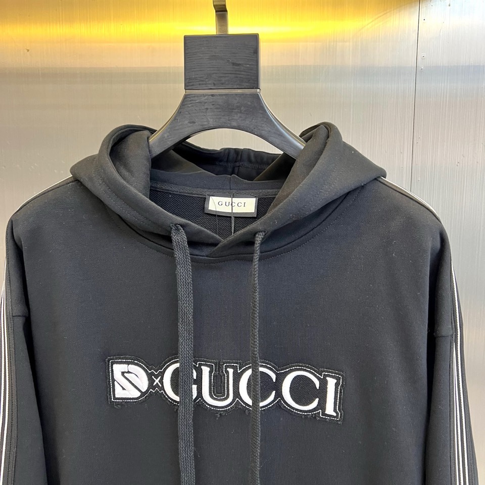 🌾Gucc古驰、2025秋冬系列以一款黑色连帽卫衣诠释经典新生。选用百搭黑色底蕴，搭配醒目白色“GUCC