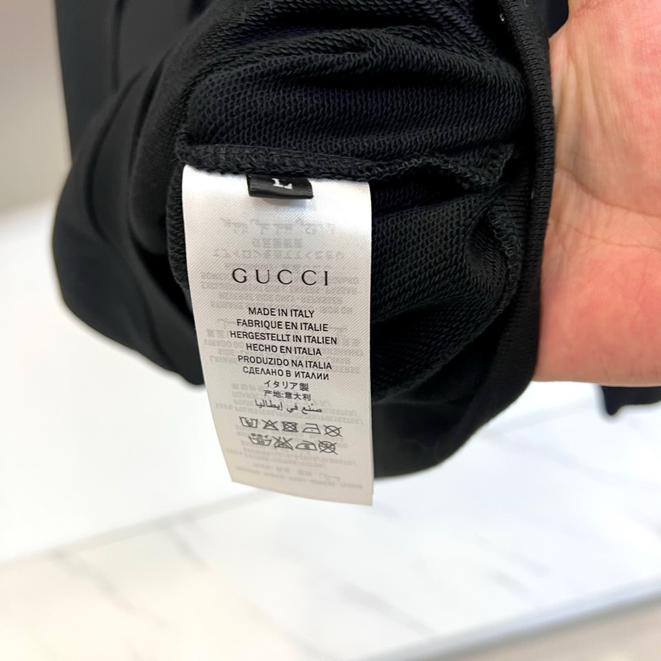 🌾Gucc古驰、2025秋冬系列以一款黑色连帽卫衣诠释经典新生。选用百搭黑色底蕴，搭配醒目白色“GUCC