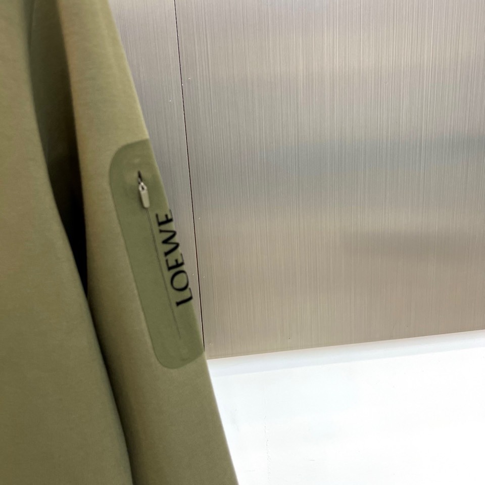 🌾罗意威、2025秋冬新款LOEWE白色圆领卫衣，以纯净白色调呈现，左胸饰有黑色品牌标志性图案，袖子上印