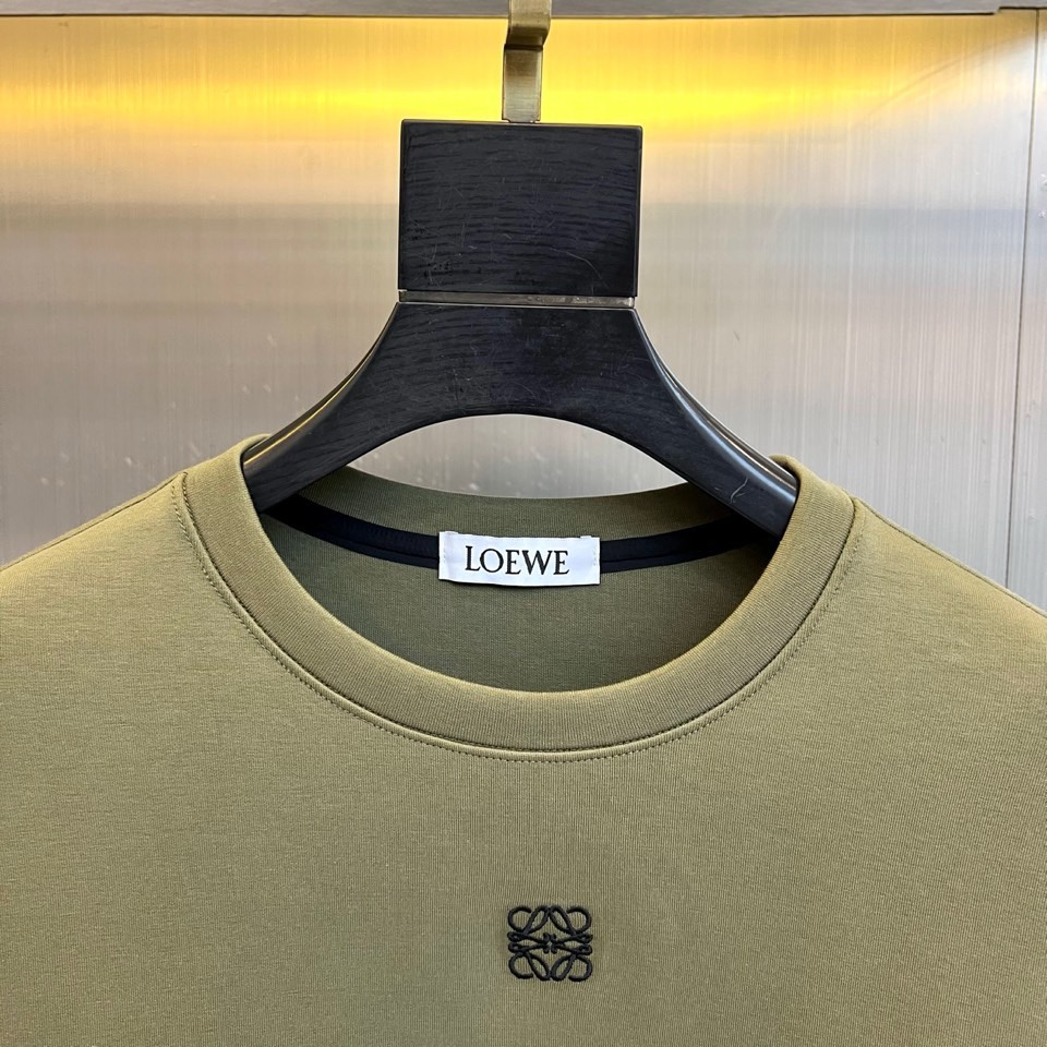 🌾罗意威、2025秋冬新款LOEWE白色圆领卫衣，以纯净白色调呈现，左胸饰有黑色品牌标志性图案，袖子上印