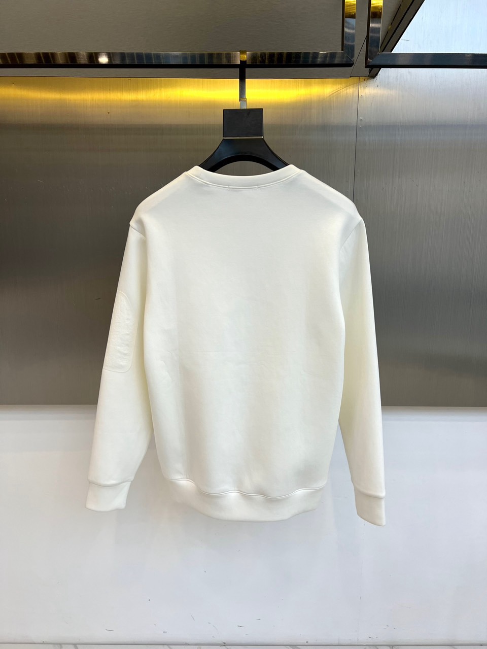 🌾罗意威、2025秋冬新款LOEWE白色圆领卫衣，以纯净白色调呈现，左胸饰有黑色品牌标志性图案，袖子上印