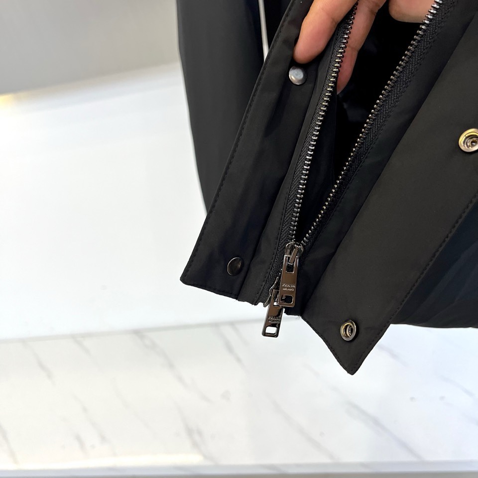 🌾普拉达（鹅绒）2025秋冬新品黑色连帽羽绒服夹克外套，以简约利落的剪裁重塑都市运动风范。采用拉链开合设