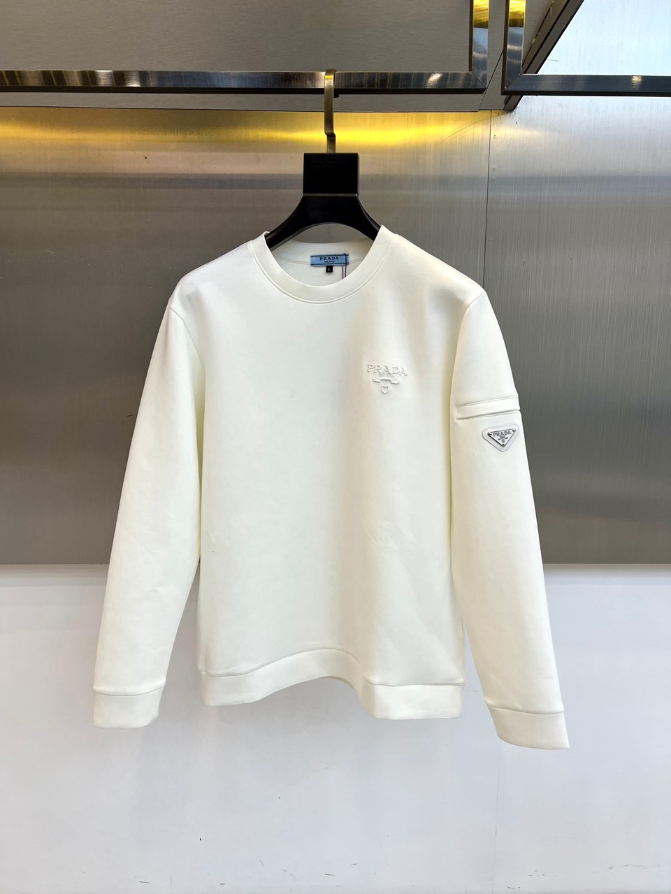 NO:726457,[After-sales service is available after the new year]  Prad, 2025 autumn and winter new air layer sweatshirt, this sweatshirt adopts a precisely tailored round neck design with a moderately loose silhouette. The brand's iconic PRADA embroidered logo is decorated on the chest. Mini functional pockets are innovatively integrated into the left sleeve arm, and the bag surface is embellished with the classic triangle logo enamel buckle.  The material uses a scientific ratio of 95 cotton and 5 spandex. The cotton base ensures skin-friendly breathability, and the spandex component gives the clothing moderate elasticity and durability. The air layer structure forms an insulating air film on the inside of the sweatshirt to achieve a dynamic balance of warmth and breathability. The care label clearly instructs machine washing water temperature control, low-temperature drying and steaming  Important points for steam ironing. The cuffs and hem adopt double-needle fine-line ribbing technology, which not only maintains the stability of the version but also enhances the fit. This design can be paired with casual trousers to show a refreshing urban image, or can be worn with a turtleneck to create a layered look. The left sleeve functional bag design takes into account both practicality and aesthetic ingenuity, with a triangle logo and embroidered logo  The details echo, perfectly reflecting Prada’s pursuit of high-end texture for daily items, becoming a must-have item across business and leisure scenes in autumn and winter. M-4XL (model weighs 173,143 pounds, upper body size L),, prada, prada, hoodie, sweatshirts,19860909【可年后售后】 Prad普拉、2025秋冬新品空气层卫衣,这款卫衣采用精准剪裁的圆领设计,配合适度宽松的版型轮廓,胸前饰有品牌标志性的PRADA刺绣标识,左袖臂处创新融入迷你功能口袋,袋面点缀经典三角徽标珐琅扣.面料采用95棉与5氨纶的科学配比,棉质基底确保亲肤透气性,氨纶成分赋予衣物适度弹性与耐久度.空气层结构在卫衣内侧形成保温空气膜,实现保暖性与透气感的动态平衡.护理标签明确指导机洗水温控制、低温烘干与蒸汽熨烫要点.袖口与下摆采用双针细线罗纹工艺,既保持版型稳定又增强贴合度.该设计既能搭配休闲裤装展现清爽都市形象,也可通过内搭高领衫构建层次穿搭,左袖功能袋设计兼顾实用性与美学巧思,三角徽标与刺绣标识的细节呼应,完美体现普拉达对日常单品的高级质感追求,成为秋冬季节跨越商务休闲场景的必备单品.M-4XL（模特173,143斤上身L码）,,prada,prada,hoodie,sweatshirts,,Men's clothing