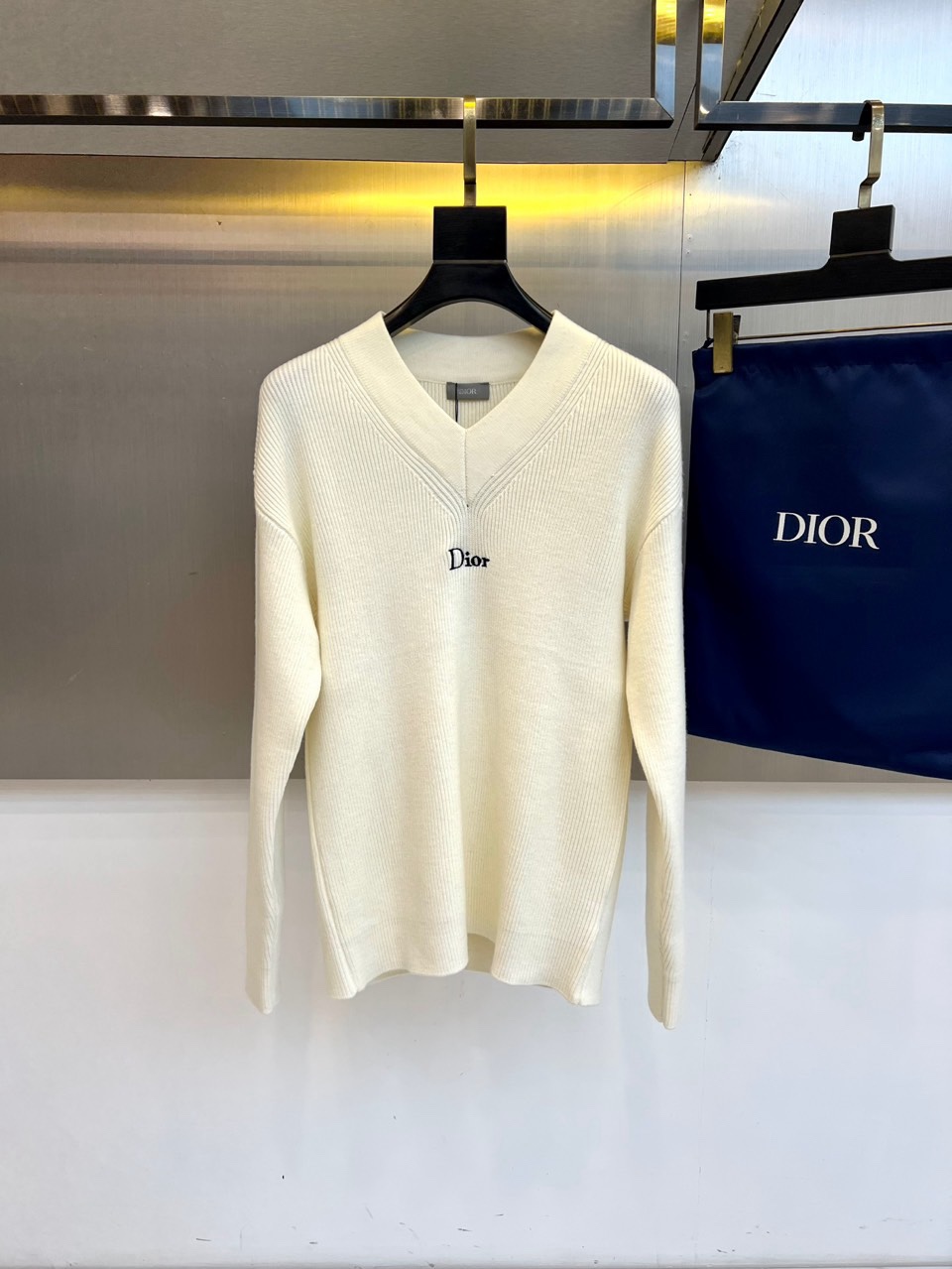 NO:726461,[After-sales service is available after the new year]  Dio Dior's new 2025 autumn and winter knitwear interprets French simple aesthetics with an elegant V-neck design. The style is made of 70% wool and 30% alpaca wool blended material. The surface of the fabric shows a delicate knitted texture, and the left chest is embellished with the classic black 'DIOR' embroidered logo. The slim tailoring is matched with ribbed trimming technology to ensure that the version is crisp and close to the body shape. Italian manufacturing standards are reflected in every detail, from the precise neckline curvature to the embroidery stitching, which demonstrates exquisite craftsmanship.  The style perfectly balances the brand's luxury genes and daily practicality. The off-white tone gives it a warm and high-end texture. The wool and alpaca blended material brings a light and warm wearing experience. The V-neck design can be worn alone to show the elegant neck line, or can be worn with a shirt to create a layered look. This sweater can be paired with a skirt for a sophisticated commute.  Style, or combined with jeans to create a casual fashion, the simple design can enhance the overall texture of the outfit, becoming an indispensable and versatile item in the autumn and winter wardrobe. 48-54 (model weighs 173,143 pounds, upper body size 50),, dior, dior, skirts, jeans, shirts,19860909【可年后售后】 Dio迪奥、2025秋冬新品针织衫以优雅V领设计诠释法式简约美学.款式采用70羊毛与30羊驼毛混纺材质,织物表面呈现细腻的针织纹理,左胸点缀经典黑色'DIOR'刺绣标志.修身剪裁搭配罗纹收边工艺,确保版型挺括且贴合身形.意大利制造标准体现在每处细节,从精准的领口弧度到刺绣针脚均彰显精湛工艺. 风格上完美平衡品牌奢华基因与日常实穿性,米白色调赋予其温暖高级的质感.羊毛与羊驼毛混纺材质带来轻盈保暖的穿着体验,V领设计既能单穿展现优雅颈部线条,也可内搭衬衫打造层次造型.这件针织衫无论是搭配半裙演绎精致通勤风,还是与牛仔裤组合营造休闲时尚,都能通过简约设计提升整体穿搭质感,成为秋冬衣橱中不可或缺的百搭单品.48-54（模特173,143斤上身50码）,,dior,dior,skirts,jeans,shirts,,Men's clothing
