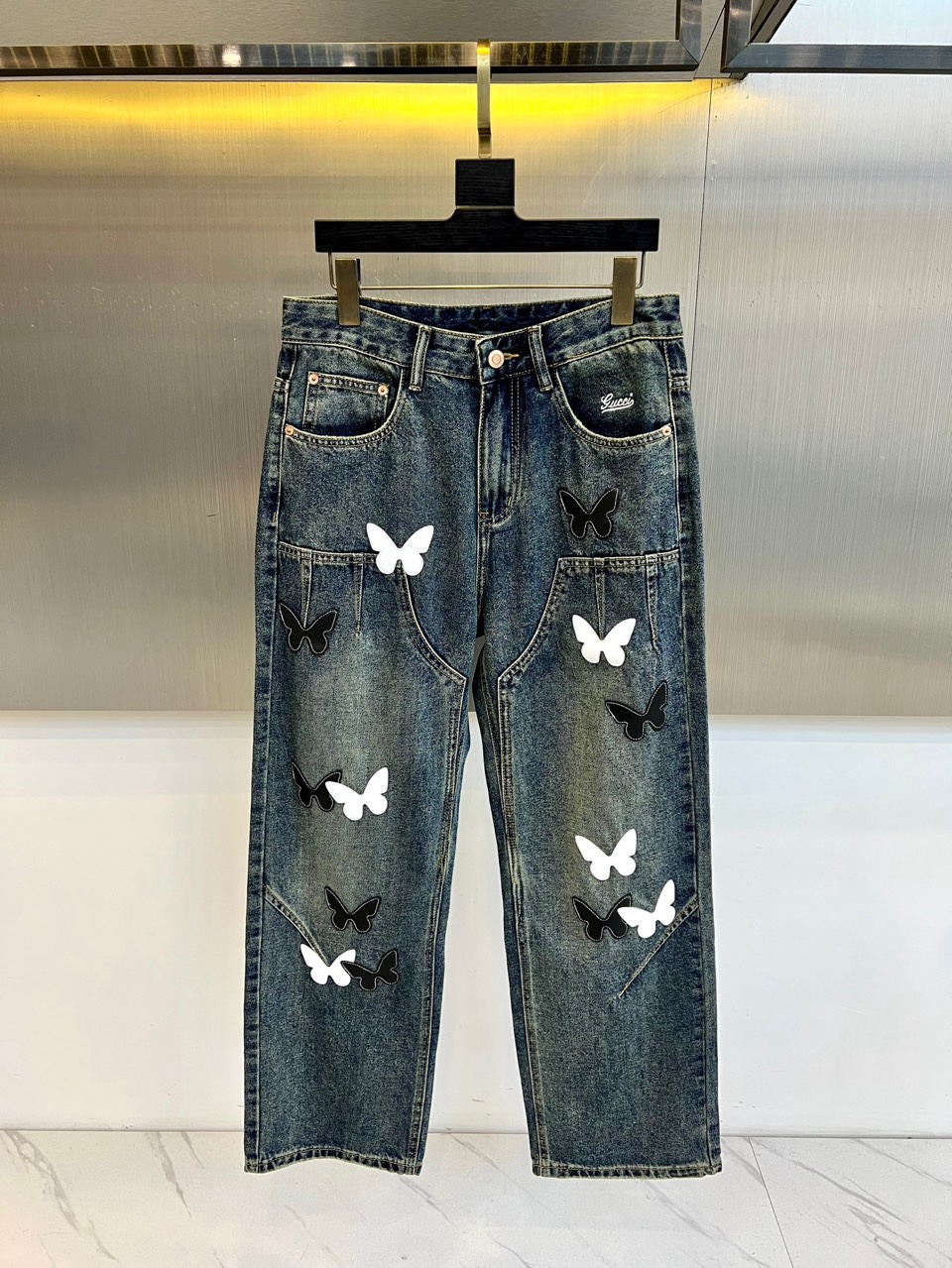 NO:726469,[Available for sale after the year] Gucci’s new jeans for autumn and winter 2025 reshape the denim silhouette with a classic straight fit, cleverly modifying the leg lines and taking into account the comfortable wearing experience. The highlight of this season’s design is the black and white butterfly appliqué embroidered all over the pants. Each butterfly is positioned with exquisite craftsmanship, as if stationary, injecting smart vitality and romantic poetry into the denim fabric.  This unique design deeply integrates street style and artistic aesthetics. Butterfly, as the iconic symbol of the brand, symbolizes freedom and fantasy, and collides with the tough temperament of cowboys to create a unique fashion spark. Its style is very expressive. Whether it is paired with a simple basic top or a layered jacket with more design, it can instantly become the core of the overall look. It is easy to create a personalized outfit with both retro charm and contemporary fashion, which perfectly interprets Gucci’s creative spirit. 29-38 (no 35  37),,gucci,gucci,jeans,jackets & coats,19860909【年后可售后】 Gucc古驰、2025秋冬新品牛仔裤,以经典直筒版型重塑牛仔廓形,巧妙修饰腿部线条,兼顾自在穿着体验.本季设计的点睛之笔在于裤身满幅铺陈的黑白蝴蝶贴布绣,每一只蝴蝶皆经精巧工艺定位,仿佛翩翩停驻,为丹宁面料注入灵动生命力与浪漫诗意. 这一独特设计将街头风范与艺术美学深度融合.蝴蝶作为品牌的标志性符号,象征着自由与梦幻,与牛仔的硬朗气质碰撞出独特的时尚火花.其风格极具表现力,无论是搭配简约基础款上衣,还是层叠更具设计感的外套,都能瞬间成为整体造型的核心,轻松打造兼具复古韵味与当代时髦感的个性穿搭,完美诠释古驰的创意精神.29-38（无35 37）,,gucci,gucci,jeans,jackets & coats,,Men's clothing