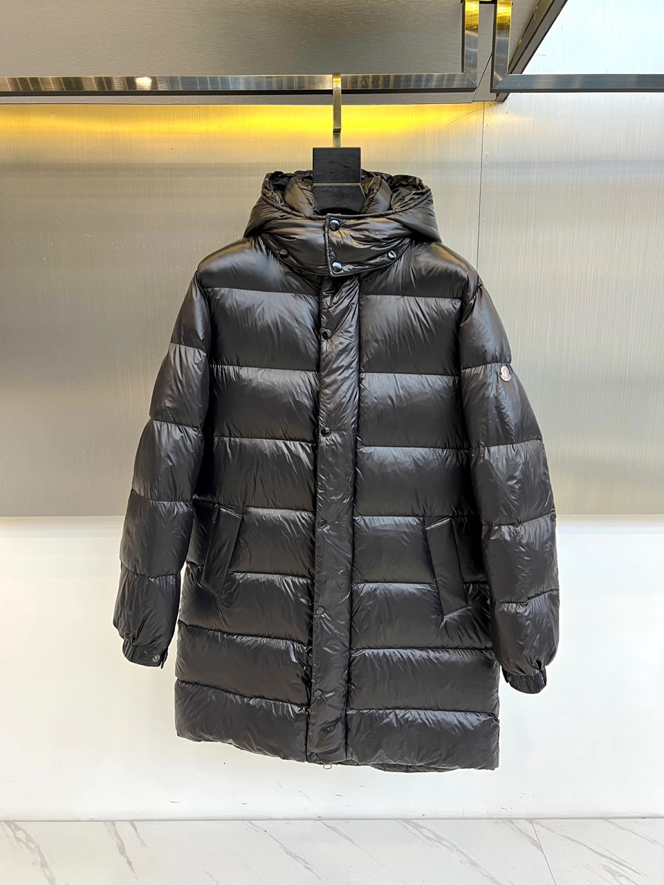 NO:726510,[Available for sale after the New Year] Mengkou's new 2025 autumn and winter down jacket reshapes the classics with ingenious tailoring. Its iconic hooded long silhouette adopts neat three-dimensional quilting technology to form regular block partitions, giving the overall simple and architectural lines. The neatly arranged snap buttons and adjustable hood cord on the front incorporate exquisite functional details into simplicity. The brand badge on the left sleeve arm is a low-key testimony of extraordinary quality.  It is filled with high-quality down to ensure excellent thermal protection in a light texture. The overall style perfectly blends urban modern aesthetics and high-end outdoor functions. The neat tailoring makes it not only easy to cope with outdoor occasions, but also becomes the core of style in winter urban wear. No matter  Whether paired with simple inner wear or layered with other winter items, it can enhance the layering and high-end texture of the overall look, making it a must-have choice for both style and warmth. 48-56 (model weighs 173,143 pounds, upper body size 50),,Moncler,down  jacket,hats,19860909【可年后售后】 蒙口2025秋冬新品羽绒服,以匠心剪裁重塑经典.其标志性连帽长款廓形采用利落的立体绗缝工艺,形成规整的块状分区,赋予整体简洁而富有建筑感的线条.正面整齐排列的按扣与可调节帽绳,在简约中融入精妙功能细节.左袖臂处的品牌徽章,低调印证非凡品质. 选用高品质羽绒填充,确保在轻盈质感中提供卓越保暖防护.整体风格完美融合了都市摩登美学与高端户外机能.利落的剪裁使其不仅能轻松应对户外场合,更能成为冬日都市穿搭中的风格核心.无论是搭配简约内搭还是与其他冬季单品叠穿,皆能提升整体造型的层次感与高级质感,成为兼具风度与温度的必备之选.48-56（模特173,143斤上身50码）,,Moncler,down jacket,hats,,Men's clothing