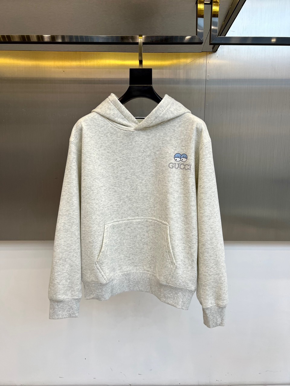 NO:730130,[After-sale after-sales service] Gucci, 2025 autumn and winter new velvet thickened hooded sweatshirt, interprets the fusion of classic and modern. The style adopts a classic hooded design and loose silhouette, with a practical chest kangaroo pocket to ensure comfort and convenience when wearing. The sweatshirt is decorated with the brand's iconic 'GUCCI' embroidery logo on the left chest, with a unique blue eye pattern embroidery next to it, showing exquisite craftsmanship in every detail. The right chest is decorated with exquisite embroidery 'MADE'  'IN ITALY' is written in a low-key manner to emphasize its pure lineage. The interior is covered with even and fine velvet fabric, which feels soft and plump and provides excellent warmth. The details highlight the extraordinary quality, including neat ribbed cuffs and hem, as well as internal labels that clearly indicate 'cotton', 'Made in Italy' and professional care guidelines, confirming its all-round attention to detail from fabric to origin.  In terms of style, this sweatshirt injects Gucci's classic aesthetic code into daily streetwear. The iconic eye pattern adds a touch of agility and artistic narrative to the simple design, while the overall low-key gray tone gives a high degree of freedom of matching. The thick velvet lining is not only a practical guarantee against the cold winter, but also improves the comfort of the wear. It can be worn alone or paired with casual pants to create an effortless chic look.  Urban style; it can also be used as an inner layer, with the hood and embroidery details exposed under the jacket, to inadvertently show high-end taste. M-4XL (model weighs 173,143 pounds, upper body size L),, gucci, gucci, hoodie, sweatshirts, jackets & coats, hats,19860909【可年后售后】 Gucc古驰、2025秋冬新品加绒加厚连帽卫衣,诠释经典与现代的融合.款式采用经典的连帽设计与宽松廓形,搭配实用的胸前袋鼠口袋,确保穿着时的舒适与便利.卫衣左胸前饰有品牌标志性的“GUCCI”刺绣标识,其旁搭配独特的蓝色眼睛图案刺绣,细节之处尽显精湛工艺.右胸前则以精巧刺绣点缀“MADE IN ITALY”字样,低调强调其纯正血统.内里覆盖均匀细密的加绒面料,触感柔软丰盈,提供卓越的保暖性.细节之处彰显非凡品质,包括工整的罗纹袖口与下摆,以及清晰标明“棉”、“意大利制造”与专业护理指南的内部标签,印证了其从面料到产地的全方位考究. 风格上,这款卫衣将古驰的经典美学代码注入日常街头服饰.标志性的眼睛图案为简约设计增添了一抹灵动与艺术叙事感,而整体低调的灰色调则赋予了极高的搭配自由度.厚实加绒内里不仅是对抗寒冬的实用保障,更提升了穿着的贴身舒适度.它既可单独穿着,搭配休闲裤装打造 effortless chic 的都市造型；亦可作为内搭层次,在外套下微露连帽与刺绣细节,于不经意间展露高级品味.M-4XL（模特173,143斤上身L码）,,gucci,gucci,hoodie,sweatshirts,jackets & coats,hats,,Men's clothing