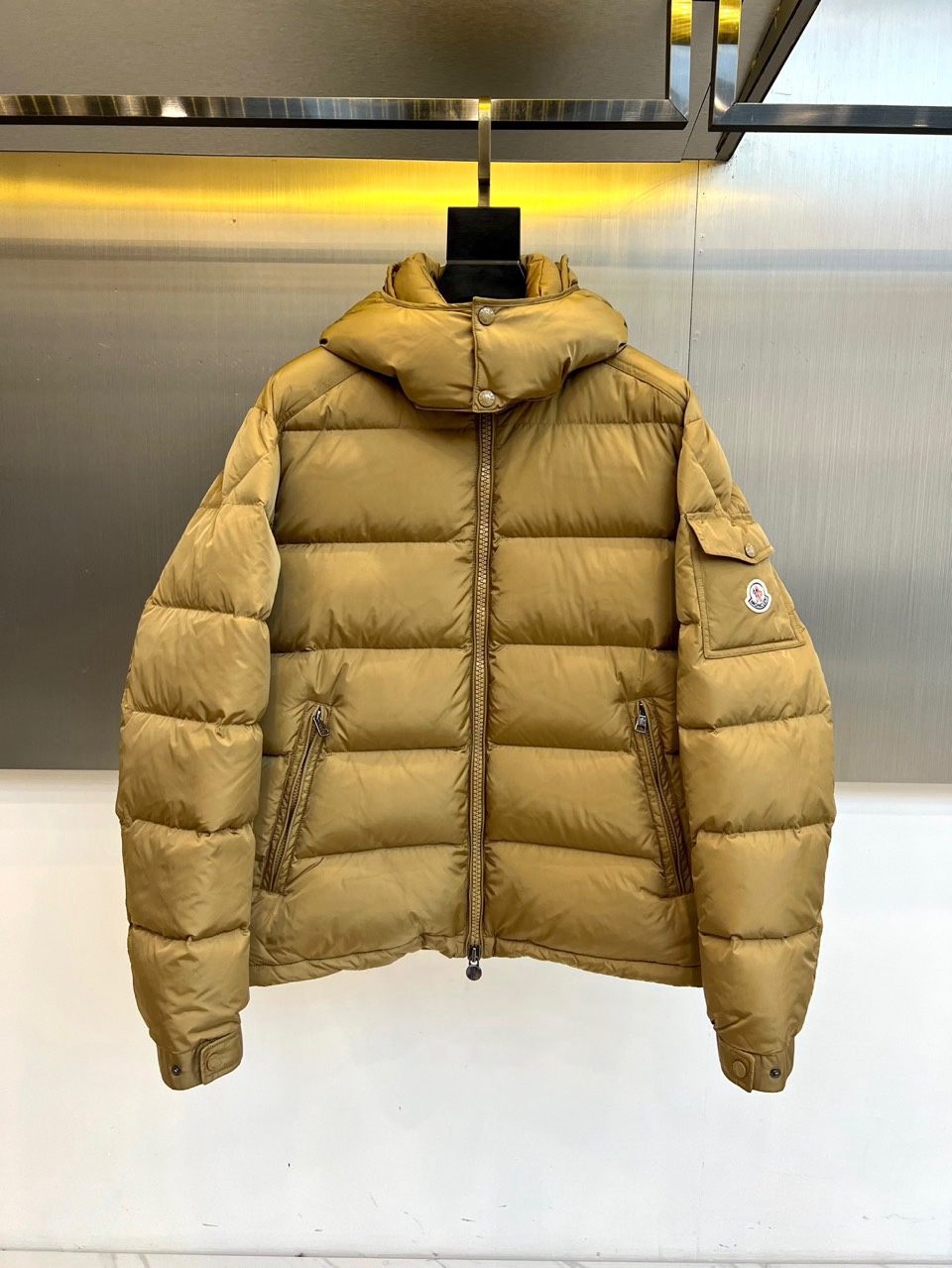 NO:730153,[After-sales service is available after the new year]  Mon (pure goose down), the new 2025 autumn and winter hooded down jacket jacket, reshapes the winter shelter with refined design and top-quality materials. This men's hooded down jacket is made of classic khaki color, showing a low-key and high-end modern temperament. Its core lies in the filling - high  Up to 90% pure goose down, light and fluffy, provides excellent temperature locking performance, complies with the strict filling standards of the United States, ensuring that every warmth is luxurious and real. The iconic three-dimensional square quilting process not only fixes the velvet material, but also outlines a neat architectural outline. Adjustable snap button hood,  The smooth front zipper and practical side zipper pockets combine functional details with simple aesthetics. The loose fit gives the body full freedom, and the exquisite brand badge on the left arm low-key proves the quality. It perfectly combines professional-level cold-proof performance with urban daily relaxation, whether it is facing  Whether you are commuting in the cold or exploring the outdoors on the weekend, you can be calm and stylish, interpreting Mengkou's consistent luxury functional philosophy of 'born in ice and snow, loyal to warmth'. Sizes 1-5 (model 173,143 pounds upper body size 2),,Moncler,jackets  & coats,jackets & coats,down jacket,hats,19860909【可年后售后】 Mon蒙口（纯鹅绒）、2025秋冬新品连帽羽绒服夹克外套,以精炼设计与顶级材质重塑冬日庇护所.这款男士连帽羽绒服选用经典卡其色,呈现低调而高级的现代气质.其核心在于填充物——高达90的纯鹅绒,轻盈蓬松,提供卓越锁温性能,符合美国严格填充标准,确保每一份温暖都奢华而实在.标志性的立体方格衍缝工艺,不仅固定绒料,更勾勒出利落的建筑感轮廓.可调节按扣连帽、顺滑前襟拉链与实用的侧边拉链口袋,兼顾功能细节与简约美学.宽松的版型赋予身体充分自由,左臂精致的品牌徽章低调印证品质.它将专业级的御寒性能与都市日常的松弛感完美融合,无论是应对严寒通勤,或是周末的户外探索,皆能从容有型,诠释了蒙口始终如一的“生于冰雪,忠于温暖”的奢华机能哲学.1-5码（模特173,143斤上身2码）,,Moncler,jackets & coats,jackets & coats,down jacket,hats,,Men's clothing