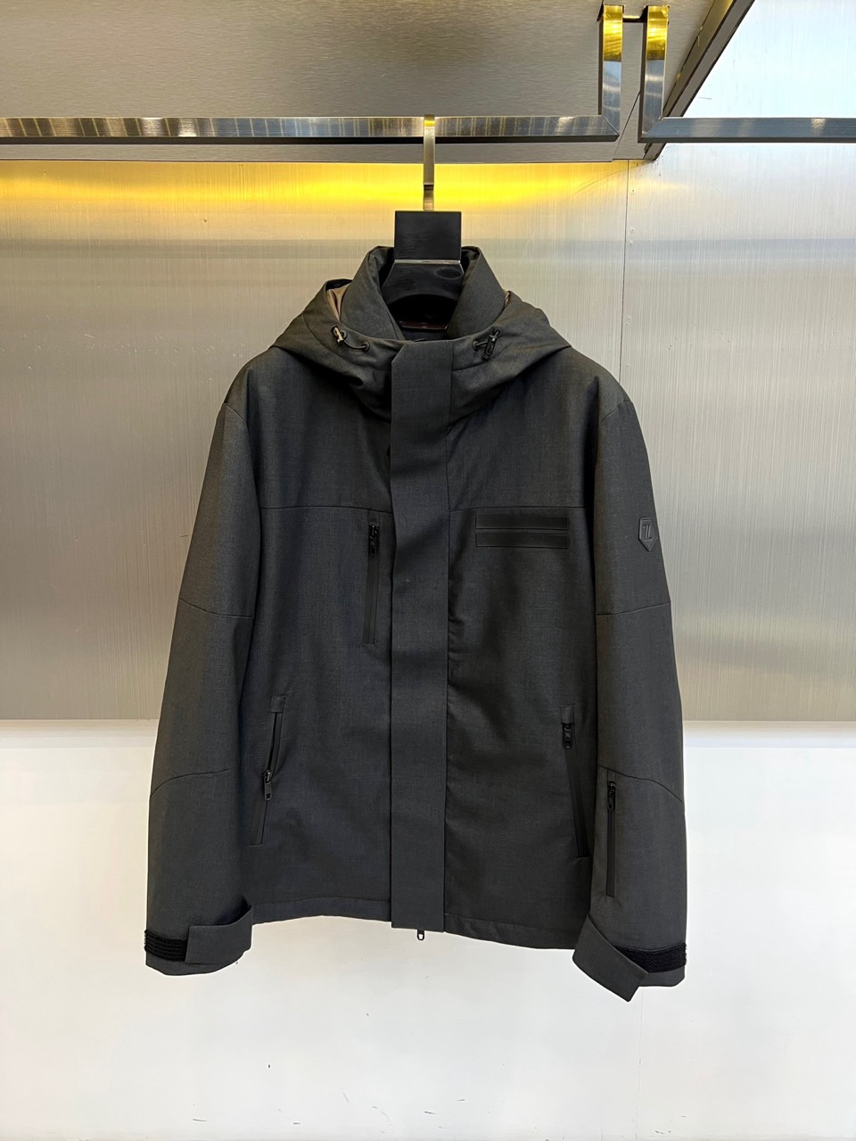 NO:730185,[Available for after-sales service after the new year] Zegna (high-end goose down), the new men's jacket for autumn and winter 2025, presents a modern and simple style in dark gray tones. The hooded design is equipped with an adjustable drawstring, taking into account both practicality and fashion. The front uses a zipper closure, the left chest is equipped with a zipper pocket, and the zipper pockets are inserted diagonally on both sides to enhance the storage function. The left sleeve is decorated with a brand logo patch, which low-key highlights the identity.  The jacket is made of innovative fabrics blended with 60% polyester, 25% merino wool and 15% viscose to create a crisp and neat silhouette while maintaining a soft touch. The interior is filled with 90% white goose down, which is lightweight and has excellent thermal insulation properties. The lining is made of polyester fiber to ensure wearing comfort.  The overall design combines functional aesthetics and Italian exquisite craftsmanship, and the neat tailoring is suitable for a variety of business and leisure scenarios. The machine-washable design (30°C gentle program) takes into account high-end quality and daily practicality, interpreting the modern gentleman's autumn and winter wardrobe model. 48-56 (model is 173,143 pounds, upper body size 50),,zegna,jackets & coats,hats,19860909【可年后售后】 Zegna杰尼亚（高端鹅绒）、2025秋冬新品男士外套,以深灰色调呈现现代简约风格.连帽设计搭配可调节抽绳,兼顾实用性与时尚感.正面采用拉链开合,左侧胸部配备带拉链口袋,两侧斜插拉链口袋增强储物功能,左袖饰有品牌标志贴片,低调彰显身份. 外套选用创新面料60聚酯纤维、25美丽诺羊毛与15粘纤混纺,打造挺括利落的轮廓的同时保持柔软触感.内里填充90白鹅绒,轻盈保暖性能卓越.里料采用聚酯纤维,确保穿着舒适度. 整体设计融合机能美学与意式精致工艺,利落剪裁适配商务休闲多种场景.可机洗设计（30℃温和程序）兼顾高端品质与日常实用性,诠释现代绅士的秋冬衣橱典范.48-56（模特173,143斤上身50码）,,zegna,jackets & coats,hats,,Men's clothing