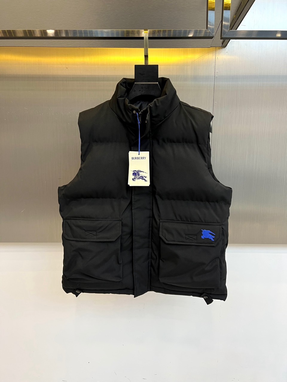 NO:730148,[After-sales service is available after the new year]  Burberry, Burberry's 2025 autumn and winter down vest, interprets timeless style in classic black. In terms of style, light and warm down filling is selected, and the stand-up collar design is neat and stylish, effectively preventing wind and cold. The front placket adopts a smooth zipper opening and closing, making it easy to put on and take off. Both sides  It is equipped with practical large-capacity pockets to meet daily storage needs. Its shape is well-tailored and its lines are smooth and crisp, ensuring freedom of movement while showing a capable silhouette. The iconic blue brand pattern embellished in the lower right corner is the finishing touch and subtly enhances recognition.  In terms of style, this vest perfectly combines pragmatism and urban style. The pure black base is very tolerant, making it easy to wear it multiple times. It can be worn with a simple sweater and casual pants to create a casual and comfortable daily image; it can also be layered on top of a suit or coat, injecting layering and modernity into business and casual looks.  Modern vitality. Whether it is for daily commuting or leisure travel, it is an ideal choice to improve the overall style, texture and functionality, showing low-key luxury British taste. 48-56 (model 173,143 pounds, upper body size 50),, burberry, burberry, down  jacket, business suit,19860909【可年后售后】 Bur巴宝莉、巴宝莉2025秋冬羽绒马甲,以经典黑色诠释隽永风尚.款式上,甄选轻盈保暖的羽绒填充,立领设计利落有型,有效防风御寒.前襟采用顺滑拉链开合,便捷穿脱.两侧设有实用大容量口袋,满足日常收纳需求.其版型剪裁精良,线条流畅挺括,在确保活动自如的同时,尽显干练轮廓.右下角点缀的标志性蓝色品牌图案,成为点睛之笔,巧妙提升辨识度. 风格上,这款马甲完美融合了实用主义与都市格调.纯粹的黑色基底极具包容性,轻松实现一衣多穿.它既能内搭简约针织衫与休闲裤,塑造随性舒适的日常形象；亦可叠穿于西装或大衣之外,为商务休闲装扮注入层次感与现代活力.无论是应对通勤日常,还是闲暇出行,它都是提升整体造型质感与功能性的理想选择,彰显低调奢华的英伦品味.48-56（模特173,143斤上身50码）,,burberry,burberry,down jacket,business suit,,Men's clothing