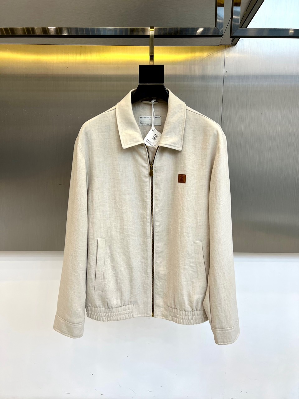 NO:732913,Brunello Cucinelli's new 2026 spring and summer jacket outlines an urban silhouette with simple lapels and neat tailoring. The metal zipper opens and closes smoothly, forming a functional echo with the adjustable drawstring hem. The three-dimensional pocket design takes into account both practicality and aesthetics. Its core lies in the selection of light and breathable innovative fabrics, which skillfully balances the crisp and stylish silhouette with the comfortable feel of spring and summer wear.  The overall cut is carefully proportioned, and the classic silhouette incorporates a micro-profile design. It can be worn with a shirt to create a smart commuting image, or with a T-shirt to interpret a weekend casual style. The unlined structure ensures freedom of movement and a light experience, and the iconic vegetable-tanned leather brand logo embellished on the body confirms exquisite craftsmanship in every detail.  This product perfectly interprets the brand's philosophy of injecting top craftsmanship into daily wear. With minimalist lines and clever functionality, it meets contemporary men's expectations for urban wear that is both refined and comfortable. 48-56 (model weighs 173,143 pounds, upper body size 50),, brunello cucinelli, jackets & coats, shirts, tees, t-shirt,19860909Brunello Cucinelli 2026春夏新品夹克,以简约翻领与利落剪裁勾勒都市廓形.金属拉链开合顺滑,与可调节抽绳下摆形成功能呼应；立体口袋设计兼顾实用与美学.其核心在于精选轻盈透气的创新面料,巧妙平衡了挺括有型的轮廓塑造与春夏穿着的舒爽体感. 整体剪裁精研比例,经典的版型中融入微廓形设计,既能内搭衬衫塑造干练通勤形象,也可搭配T恤诠释周末休闲风格.无衬里结构确保了活动自如与轻盈体验,衣身点缀的标志性植鞣皮革品牌标牌,于细节处印证精湛工艺. 本品完美诠释了品牌将顶级工艺注入日常着装的哲学,以极简线条和巧妙功能性,满足当代男士对精致与舒适兼具的都市着装期待.48-56（模特173,143斤上身50码）,,brunello cucinelli,jackets & coats,shirts,tees，t-shirt,,Men's clothing