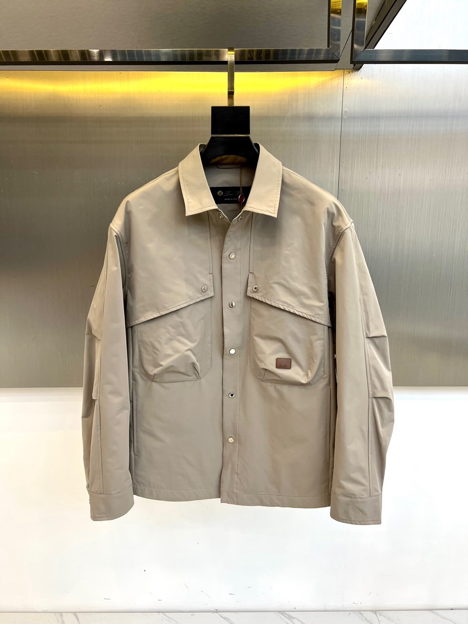 NO:732933,Loro Piana's 2026 spring and summer new shirt-style jacket is designed with classic lapels and button placket, interpreting Italian casual elegance. The two three-dimensional large pockets on the chest combine practical functions and structural aesthetics. The right pocket is decorated with a small decorative plate, showing exquisite craftsmanship in the details. The overall design is loose and the lines are smooth, creating a free and relaxed silhouette.  This product selects the brand's signature high-performance natural blended fabrics, which are light in texture, delicate and smooth to the touch, have excellent breathability and drape, and perfectly suit the needs of spring and summer climate. Its design cleverly combines the pragmatism of workwear with the simple silhouette of high fashion.  The style perfectly balances laziness and sophistication. It can be worn with a T-shirt and jeans for a casual everyday, or paired with sports-style bottoms to create a fashionable urban casual feel. It is a versatile and key item that can easily improve the overall look and comfort. 48-56 (model weighs 173,143 pounds, upper body size 50), loro piana, jeans, jackets & coats, shirts, tees, t-shirt,19860909Loro Piana 2026春夏新品衬衫式外套,以经典翻领与纽扣开襟设计,诠释意式休闲优雅.胸前两枚立体大口袋兼具实用功能与结构美学,右侧口袋缀以小巧装饰牌,于细节处彰显精湛工艺.整体采用宽松剪裁,线条流畅,营造自在松弛的廓形. 本品精选品牌标志性的高性能天然混纺面料,质感轻盈,触感细腻柔滑,具备出色的透气性与垂坠感,完美适配春夏气候需求.其设计巧妙融合了工装的实用主义与高级时装的简约轮廓. 风格上完美平衡了慵懒与精致,既可内搭T恤与牛仔裤演绎随性日常,亦可搭配运动风格下装营造时髦的都市休闲感.是一款百搭多变、能轻松提升整体造型质感与舒适度的关键单品.48-56（模特173,143斤上身50码）,,loro piana,jeans,jackets & coats,shirts,tees，t-shirt,,Men's clothing