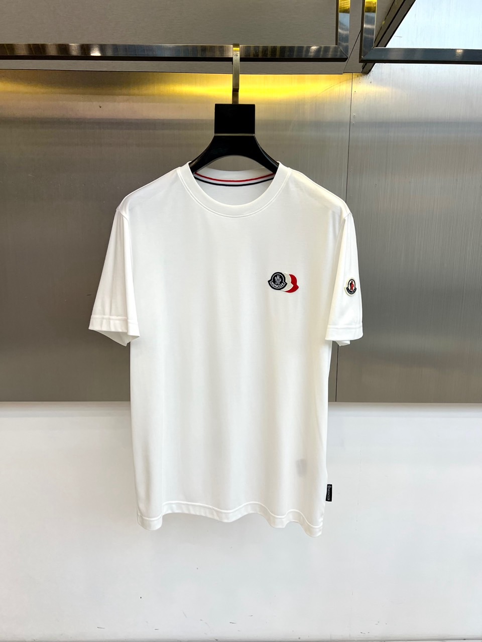 NO:732973,Mon, the 2026 spring and summer new short-sleeved T-shirt, uses a classic round neck short-sleeved silhouette to interpret pure and simple modern casual aesthetics. The iconic design is condensed in the exquisite brand badge on the left chest, which combines three-dimensional embroidery and metallic details to instantly  It brightens up the overall look. The left cuff is embellished with the brand logo patch of the same series, showing exquisite craftsmanship in every detail. The single product is specially selected from innovative blended fabrics, which combines the softness of cotton, the silky luster of modal and the excellent stiffness of polyester fiber, bringing extraordinary  Skin-friendly touch and breathable experience. Its tailoring lines are smooth and neat, perfectly balancing the freedom of body movement and the drape texture. Whether it is daily commuting, weekend leisure or light sports, this T-shirt can easily adapt to multiple scenes, create a natural, comfortable and stylish spring and summer image, and interpret a calm attitude derived from nature and integrated into life. 48-56 (model 173, 143 pounds, upper body size 50), Moncler, T-shirt, tees, t-shirt,19860909Mon蒙口、2026春夏新品短袖T恤,以经典圆领短袖廓形,诠释纯粹简约的现代休闲美学.标志性设计凝聚于左胸处的精致品牌徽章,融合立体刺绣与金属质感细节,瞬间点亮整体造型.左袖口点缀同系列品牌标识贴布,于细微处彰显精湛工艺.单品特别选用创新混纺面料,融合棉的柔软、莫代尔的丝滑光泽与聚酯纤维的优良挺括性,带来非凡的亲肤触感与透气体验.其剪裁线条流畅利落,完美平衡身体活动自由度与垂坠质感.无论是日常通勤、周末休闲或轻量运动,这款T恤都能轻松适配多元场景,塑造自然舒适且不失格调的春夏形象,诠释源自自然、融入生活的从容态度.48-56（模特173,143斤上身50码）,,Moncler,T-shirt,tees，t-shirt,,Men's clothing