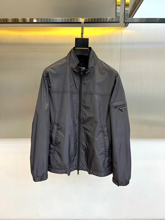 NO:732983,Prad, the new men's jacket for spring and summer 2026, outlines a modern urban silhouette with a simple stand-up collar and neat tailoring. Smooth zipper opening and closing ensures easy putting on and taking off, and smooth and pure lines. Its iconic design is the brand's classic triangular metal logo embellished on the left sleeve, which demonstrates the timeless identity and exquisite craftsmanship in every detail. Redundant decoration is abandoned as a whole, focusing on the precise expression of tailoring and structure.  This product uses crisp and lightweight high-performance fabrics to ensure that it is comfortable, breathable and has a clear silhouette when worn in spring and summer. The essence of its style lies in the perfect balance between pragmatism and high-end fashion, translating minimalist aesthetics into the language of daily dressing.  Whether it is paired with casual denim pants to interpret a casual style, or combined with formal trousers to create a modern business casual look, it can be easily controlled and has become a key item that connects different scenes and shows a restrained and confident Prada style. 48-56 (model is 173,143 pounds, upper body size 50),, prada, prada, jackets & coats,19860909Prad普拉、2026春夏新品男士夹克,以简约立领与利落剪裁,勾勒现代都市廓形.顺滑拉链开合确保穿脱便捷,线条流畅纯粹.其标志性设计在于左袖处点缀的品牌经典三角形金属徽标,于细微处彰显隽永身份与精湛工艺.整体摒弃冗余装饰,专注剪裁与结构的精准表达. 本品选用挺括轻盈的高性能面料,确保春夏穿着时舒爽透气且轮廓分明.其风格精髓在于完美平衡了实用主义与高级时装感,将极简美学转化为日常着装语言. 无论是搭配休闲丹宁裤诠释随性风尚,或是与正装西裤组合塑造摩登的商务休闲造型,皆能从容驾驭,成为连接不同场景、展现克制而自信的普拉达式型格的关键单品.48-56（模特173,143斤上身50码）,,prada,prada,jackets & coats,,Men's clothing