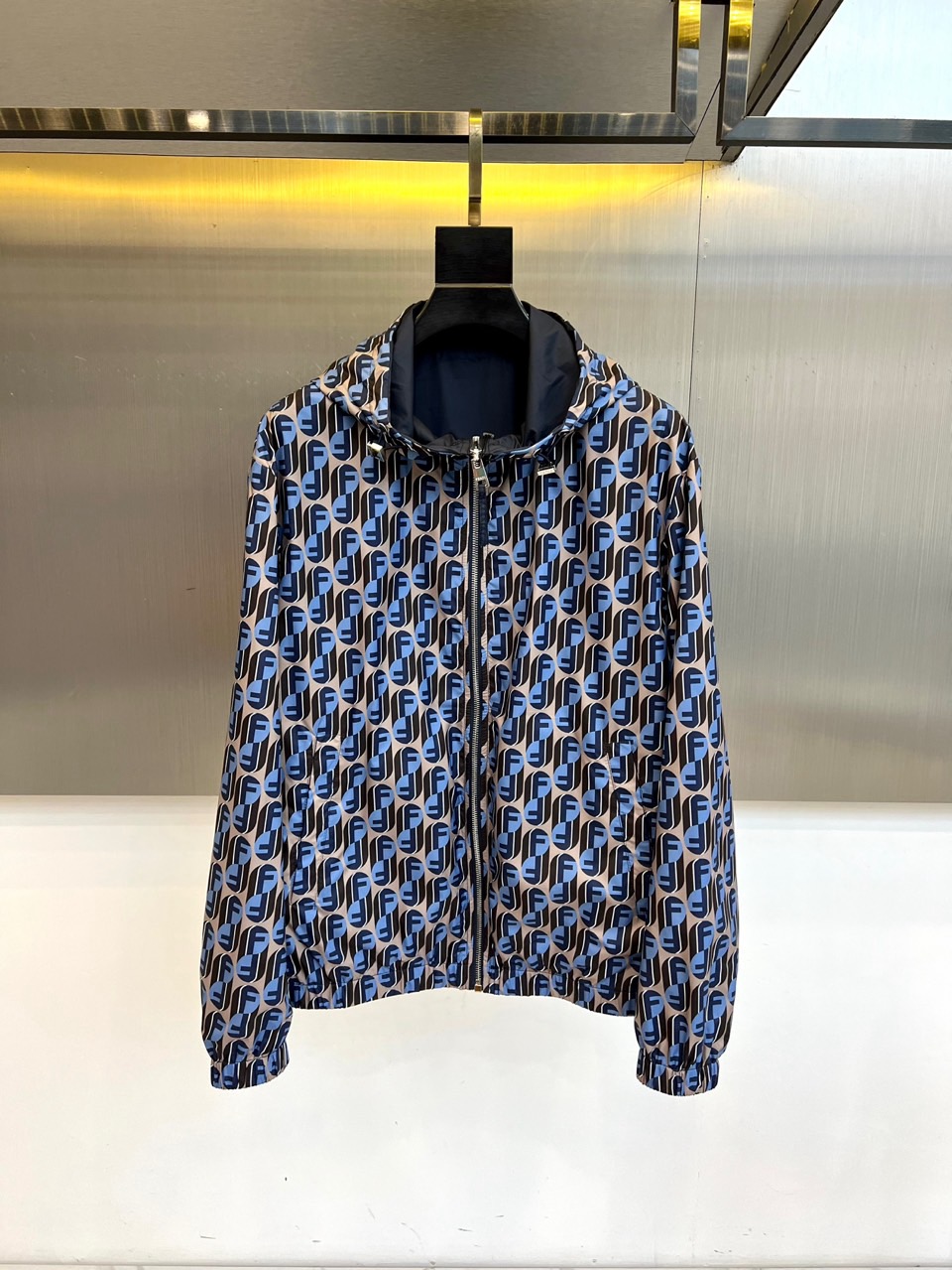 NO:732993,Fend Fendi, 2026 spring and summer men's reversible hooded jacket, with its iconic zipper opening and double-sided design, presents the ingenious idea of wearing one garment for multiple purposes. The outer layer is neatly cut, and the surface is covered with rhythmic geometric patterns, showing a highly recognizable modern aesthetic. The inner layer is decorated with a delicate FF letter printed lining, which can be instantly switched between two completely different styles and wearing experiences by flipping it inside out. The left chest is embellished with the brand's classic FF logo embroidery, highlighting the luxury gene.  The single product is made of polyester fiber fabric to ensure that the garment is light, crisp and durable, and meets the standards of non-direct contact with the skin. Its design perfectly blends urban sports style and high-end fashion sense, whether it is worn with the patterned side outside and simple bottoms to create a street style; or the inner lining is turned out to display the brand print in a low-key manner  The details can easily adapt to the diverse scenes of daily commuting and leisure travel. This functional jacket is a smart choice for creating changeable spring and summer looks, showing a calm Italian fashion attitude. 48-56 (model is 173,143 pounds, upper body size 50),, fendi, fendi, jackets  & coats,hats,19860909Fend芬迪、2026春夏男士双面穿连帽外套,以标志性拉链开合与双面设计,呈现一衣多穿的精妙巧思.外层采用利落剪裁,表面满幅铺陈富有韵律感的几何图案,展现出极具辨识度的现代美学.内层则饰以精致的FF字母印花内衬,通过内外翻转即可瞬间切换两种截然不同的风格与穿着体验.左胸点缀品牌经典FF标识刺绣,彰显奢华基因. 单品选用聚酯纤维面料,确保成衣拥有轻盈、挺括且耐用的特性,符合非直接接触皮肤标准.其设计完美融合了都市运动风范与高级时尚感,无论是将图案面外穿搭配简约下装,塑造街头型格；或将内衬面外翻,低调展现品牌印花细节,都能轻松适应日常通勤与休闲出行的多元场景.这件功能性外套是打造多变春夏造型的智慧之选,尽显从容的意式时尚态度.48-56（模特173,143斤上身50码）,,fendi,fendi,jackets & coats,hats,,Men's clothing