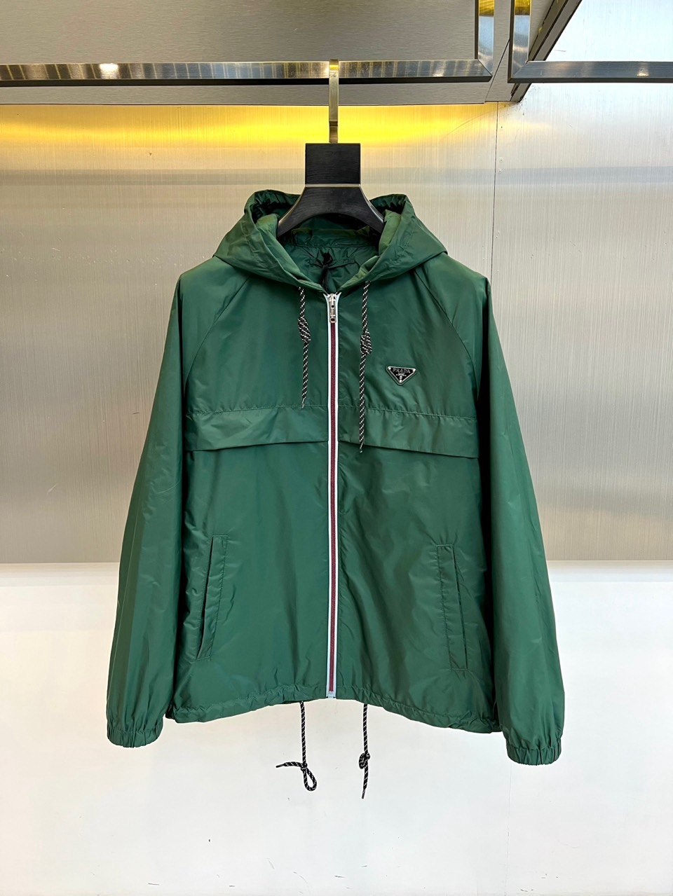 NO:732974,Prad, the new 2026 spring and summer hooded jacket, interprets modern urban style with neat tailoring and iconic details. The classic triangle logo is embellished on the left chest, highlighting the brand's timeless identity. The hooded design is equipped with an adjustable drawstring, taking into account both protective performance and styling freedom. The front zipper opens smoothly, and three-dimensional pockets are integrated on both sides, cleverly balancing practical functions and simple beauty. The slim silhouette fits the body shape.  Ensure freedom of movement. This product injects high-end fashion craftsmanship into daily design, easily adapting to various occasions. Whether paired with jeans to create a casual style, or combined with sports pants to show a dynamic style, it can become a key item to create a multi-layered spring and summer outfit. 48-56 (model 173,143 pounds, upper body size 50),, prada, prada, jeans, jackets  & coats,hats,19860909Prad普拉、2026春夏新品连帽外套,以利落剪裁与标志性细节诠释现代都市风格.经典三角徽标点缀于左胸,彰显品牌隽永身份.连帽设计搭配可调节抽绳,兼顾防护性能与造型自由度.正面顺滑拉链开合,两侧融入立体口袋,巧妙平衡实用功能与简约美感.修身廓形贴合身形,确保活动自如.本品将高级时装工艺注入日常设计,轻松适配多样场合,无论是搭配牛仔裤演绎休闲风尚,或结合运动裤展现活力型格,皆能成为塑造春夏多层次穿搭的关键单品.48-56（模特173,143斤上身50码）,,prada,prada,jeans,jackets & coats,hats,,Men's clothing