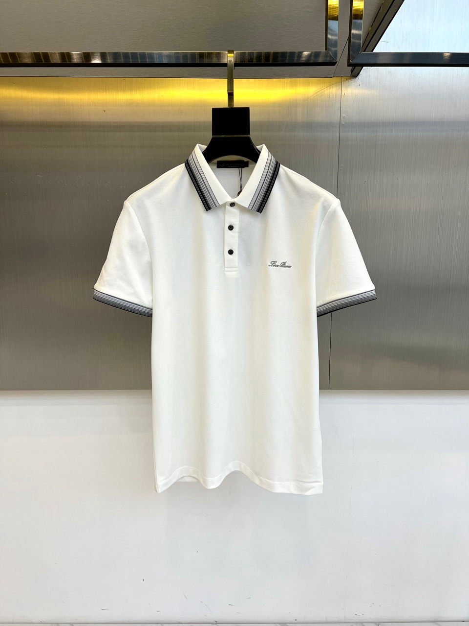 NO:734815,Loro  Piana's elegant, 2026 spring and summer men's Polo shirt interprets contemporary simple aesthetics with a classic version. The style adopts a classic lapel and button placket design, which is neat and decent. The ingenuity is that the collar, placket and cuffs are all decorated with exquisite striped webbing of the same color, forming a subtle and rich texture contrast with the main fabric, highlighting the exquisite craftsmanship and level of detail. The chest is decorated with small  The brand logo embroidery shows off the taste in a low-key way. Its style cleverly balances business casual and daily elegance, and the clever integration of stripe elements injects a quiet sense of fashion into the classic style. Whether paired with casual pants or suit pants, it can calmly cope with a variety of occasions, showing a confident and calm modern gentleman style. 48-56 (model is 173, 143 pounds, upper body size 50),, loro  piana,business suit,19860909Loro Piana诺悠翩雅、2026春夏男士Polo衫,以经典版型诠释当代简约美学.款式采用经典翻领与纽扣门襟设计,利落得体.匠心之处在于领口、门襟及袖口均饰有精致的同色系条纹织带,与主体面料形成含蓄而丰富的肌理对比,凸显精湛工艺与细节层次.胸前点缀小巧的品牌标识刺绣,低调彰显品味.其风格巧妙平衡了商务休闲与日常优雅,条纹元素的巧妙融入为经典款式注入一丝不动声色的时髦感.无论搭配休闲裤或西装裤,皆能从容应对多种场合,展现自信从容的现代绅士风范.48-56（模特173,143斤上身50码）,,loro piana,business suit,,Men's clothing
