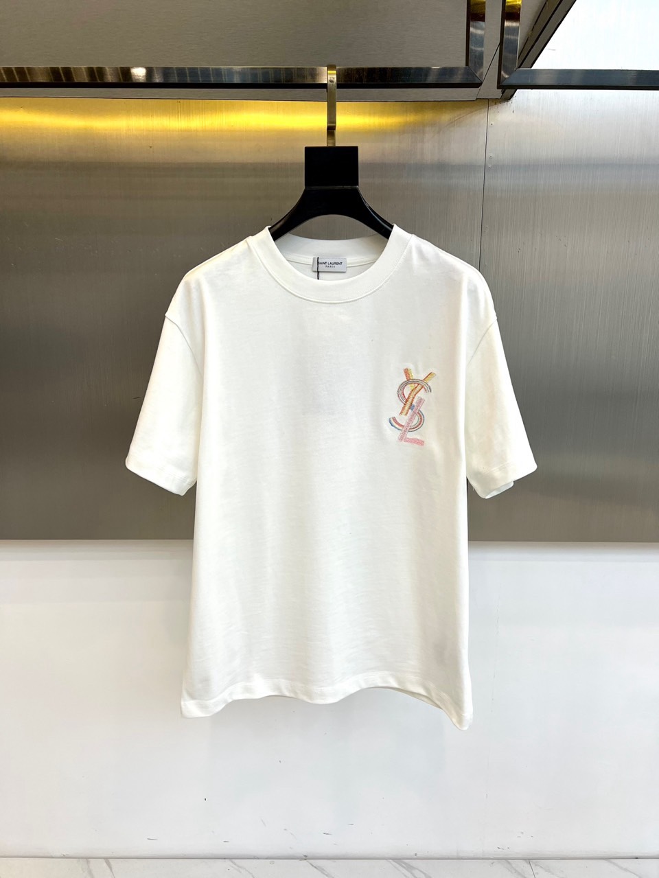 NO:734801,YSL Saint Laurent, 2026 spring and summer new T-shirt, interprets the French uninhibited spirit with a simple silhouette. The style adopts a classic round neck and neat short-sleeved tailoring, and the loose version gives the body free space. The left chest is embellished with unique colorful monogram embroidery, which forms the visual focus with delicate craftsmanship and subtly enhances the brand recognition and artistic sense. Its style perfectly captures the essence of the brand - integrating the rock-like rebellious attitude into daily wear, hiding sophistication in the casualness. Whether it is paired with jeans to perform like a Parisian street  Effortless chic, or layered with leather items to create a cool look, this T-shirt can become the key item connecting day and night, laziness and style, confidently showing the avant-garde charm of Saint Laurent. S-XXL (model weighs 173,143 pounds, upper body size M),, saint laurent, saint laurent, jeans, T-shirt, tees, t-shirt,19860909YSL圣罗兰、2026春夏新品T恤,以简约轮廓诠释法式不羁精神.款式采用经典圆领与利落短袖剪裁,宽松版型赋予身体自在空间.左胸处点缀别致的彩色交织字母刺绣,以细腻工艺构成视觉焦点,巧妙提升品牌辨识度与艺术感. 其风格完美捕捉了品牌精髓——将摇滚般的叛逆态度融入日常穿着,在随性中暗藏精致.无论是搭配牛仔裤演绎巴黎街头般的 effortless chic,还是与皮革单品层叠塑造酷感造型,这件T恤都能成为连接日与夜、慵懒与型格的关键单品,自信展现圣罗兰式的前卫魅力.S-XXL（模特173,143斤上身M码）,,saint laurent,saint laurent,jeans,T-shirt,tees，t-shirt,,Men's clothing