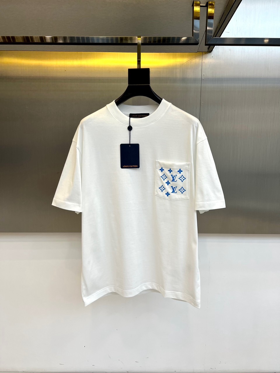 NO:734822,1v Vuitton, 2026 spring and summer T-shirt, interprets a casual attitude with a simple round neck and comfortable and loose fit. The core of the design lies in the flap pocket on the chest, whose surface is densely covered with the brand's iconic Monogram presbyopic pattern, and is carefully presented with exquisite embroidery technology, giving the classic pattern a delicate and luxurious texture, becoming an irreplaceable visual focus. The overall style cleverly balances the leisure  The casual silhouette and haute couture-like details integrate street vitality with the brand's century-old genes. Whether paired with denim items or casual trousers, it can easily inject a casual luxury style into daily looks, becoming the finishing touch of taste in the spring and summer wardrobe. 48-56 (model weighs 173,143 pounds, upper body size 50),, tees, t-shirt,198609091v威登、2026春夏T恤,以简约圆领与舒适宽松版型诠释随性态度.设计核心在于胸前的翻盖口袋,其表面密覆品牌标志性Monogram老花图案,并以精湛的刺绣工艺精心呈现,赋予经典纹样以细腻奢华的肌理感,成为无可替代的视觉焦点.整体风格巧妙平衡了休闲的廓形与高级定制般的细节,将街头活力与品牌百年基因融为一体.无论是搭配丹宁单品或休闲长裤,都能轻松为日常造型注入一份不经意的奢华格调,成为春夏衣橱中彰显品味的点睛之作.48-56（模特173,143斤上身50码）,,tees，t-shirt,,Men's clothing