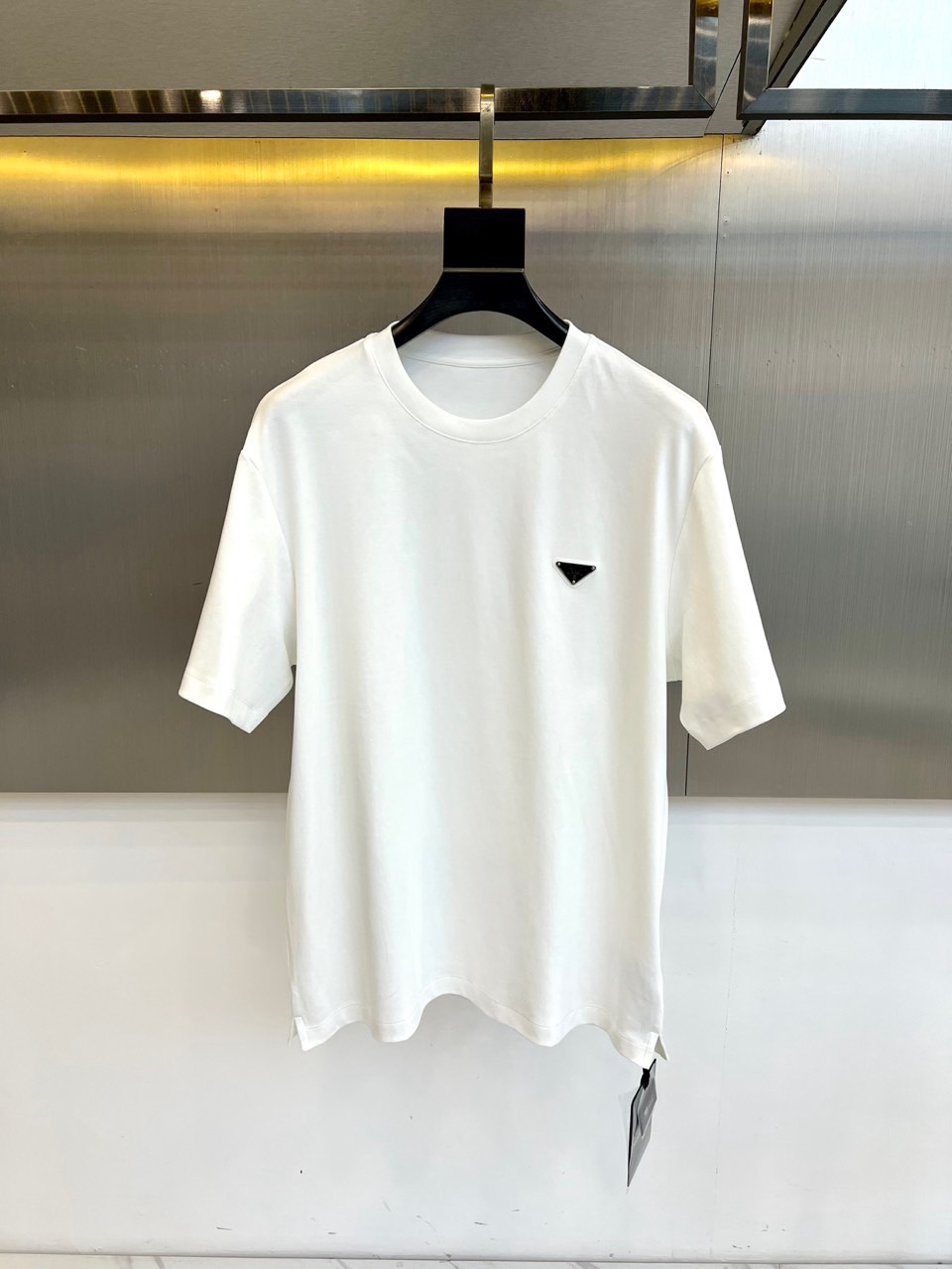 NO:734838,Prad, the new men's short-sleeved T-shirt for spring and summer 2026, interprets modern minimalism with a classic round neck and neat tailoring. The essence of its design lies in the exquisite triangular logo on the left chest, derived from the brand's classic emblem, which low-key shows its extraordinary identity in a simple silhouette. The version is loose and moderate, and the lines are smooth, creating an unrestricted wearing experience.  This product is carefully selected from the finest water-soft cotton fabrics. It has a fine weave and is extremely soft and skin-friendly. It has excellent breathability and drape. It is specially designed for the daily life in spring and summer that pursues top comfort. The fabric composition and technology are strictly in compliance with national standards, and the quality is reliable.  The overall style perfectly combines Italian luxury craftsmanship with a sense of street casualness, turning iconic symbols into restrained embellishments. Whether paired with casual trousers to create a daily style, or worn under a suit jacket to add layers, it can easily enhance the texture and taste of the look, becoming a core item for building a high-end basic wardrobe. 48-56 (model 173,143 pounds, upper body size 50),, prada, prada, jackets & coats, T-shirt, tees, t-shirt, business suit,19860909Prad普拉、2026春夏新品男士短袖T恤,以经典圆领与利落剪裁诠释现代极简主义.其设计精髓在于左胸处的精致三角形标志,源自品牌经典徽章,于简约廓形中低调彰显非凡身份.版型宽松有度,线条流畅,打造无拘的穿着体验. 本品严选极品水柔棉面料,织法细密,触感异常柔软亲肤,兼具卓越的透气性与垂坠感,专为追求顶级舒适度的春夏日常而设计.面料成分及工艺均严格执行国家标准,品质可靠. 整体风格完美融合了意式奢华工艺与街头休闲感,将标志性符号化为内敛的点缀.无论是搭配休闲裤装演绎日常型格,或作为内搭于西装外套之下增添层次,皆能轻松提升造型的质感与品味,成为构建高端基础衣橱的核心单品.48-56（模特173,143斤上身50码）,,prada,prada,jackets & coats,T-shirt,tees，t-shirt,business suit,,Men's clothing