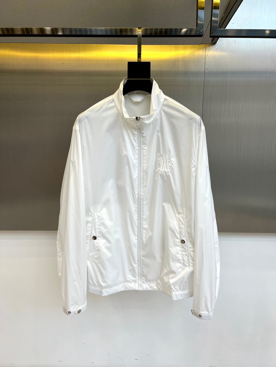 NO:734865,Mon, the 2026 spring and summer men's jacket, outlines a modern urban silhouette with a neat stand-up collar and smooth tailoring. The collar is embellished with exquisite details, highlighting the ingenuity of the design. The front is closed with a zipper, and is equipped with diagonal pockets on both sides. The pockets are reinforced with metal snaps, which combines practical functions with tough aesthetics. The cuffs are also equipped with adjustable metal snaps to ensure a good fit and windproofness. The brand letters are embroidered on the left chest, low-key highlighting the fit.  The whole body is made of crisp fabrics to shape neat lines. Its style perfectly combines functionalism and simple aesthetics. Whether it is daily commuting or leisure travel, this jacket can easily handle it. It enhances the overall shape with neat tailoring and exquisite details, interpreting a leisurely urban style. 48-56 (model 173, 143 pounds, upper body size 50), Moncler, jackets  & coats,19860909Mon蒙口、2026春夏男士夹克,以利落立领与流畅剪裁勾勒现代都市廓形.领口点缀精致细节,凸显设计巧思.正面采用拉链闭合,搭配两侧斜插口袋,口袋以金属按扣加固,兼具实用功能与硬朗美感.袖口同样配备可调节金属按扣,确保贴合防风.左胸处的品牌字母刺绣,低调彰显身份.整体选用挺括面料,塑造利落线条.其风格完美融合了功能主义与简约美学,无论是日常通勤或休闲出行,这件夹克都能轻松应对,以利落剪裁与精致细节提升整体造型感,诠释从容不迫的都市型格.48-56（模特173,143斤上身50码）,,Moncler,jackets & coats,,Men's clothing