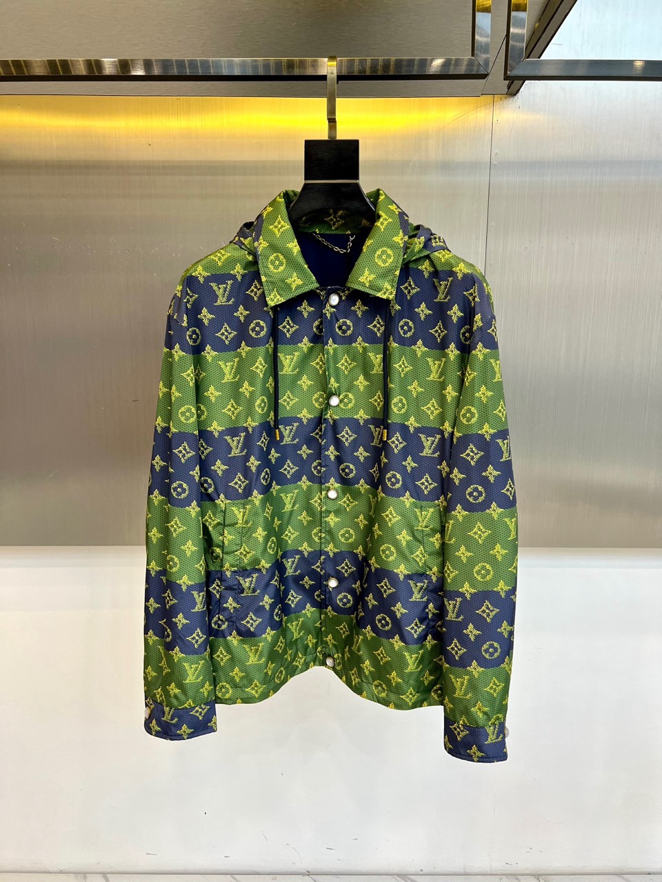 NO:734869,1v Vuitton, 2026 spring and summer men's jacket, cleverly combines classic genes and modern sports style. The piece adopts a unique hooded and lapel design, which has both a free and easy feel and a neat silhouette. The iconic Monogram pattern is spread all over the body, and through exquisite depth and shallow layer processing, it gives the classic pattern a vivid and three-dimensional new visual expression. The front is equipped with practical button closure, and there are pockets on both sides, with exquisite details.  The jacket is made of polyester fiber fabric to ensure that the garment is crisp and stylish and meets the lightweight needs of spring and summer. The essence of its design is to integrate luxury totems into daily styles, breaking the boundaries between formal and casual wear. Whether it is paired with a simple sweater to create an urban wandering image, or layered with a T-shirt  In addition to interpreting the street fashion attitude, this coat can become the key to improving the overall look and texture, perfectly interpreting Louis Vuitton's precise insight into the diverse lifestyles of contemporary men. 48-56 (model is 173,143 pounds, upper body size 50),,louis  vuitton,jackets & coats,tees,t-shirt,hats,198609091v威登、2026春夏男士外套,巧妙融合经典基因与现代运动风格.单品采用独特的连帽结合翻驳领设计,兼具洒脱感与利落廓形.衣身满幅铺陈标志性Monogram图案,通过精妙的深浅层次处理,赋予经典花纹以生动而立体的全新视觉表达.前襟配备实用纽扣开合,两侧设有口袋,细节考究. 外套选用聚酯纤维面料,确保成衣挺括有型并满足春夏轻便需求.其设计精髓在于将奢华图腾融入日常化版型,打破正装与休闲的界限.无论是搭配简约针织衫塑造都市游走形象,或层叠于T恤之外诠释街头时髦态度,这件外套都能成为提升整体造型质感的关键,完美诠释路易威登对当代男士多元化生活方式的精准洞察.48-56（模特173,143斤上身50码）,,louis vuitton,jackets & coats,tees，t-shirt,hats,,Men's clothing