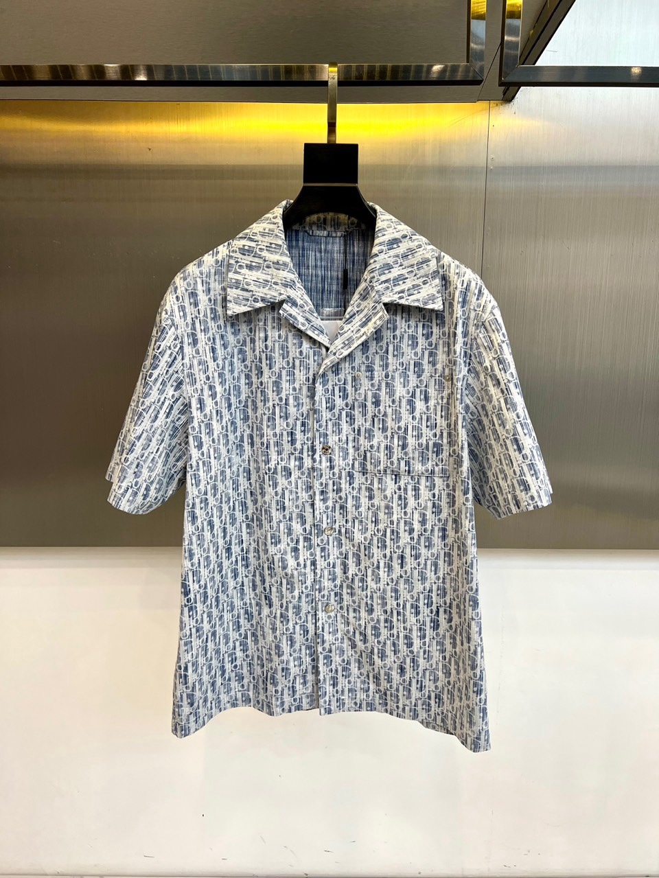 NO:734873,Dio, the 2026 spring and summer men's short-sleeved shirt, interprets summer elegance with a classic lapel silhouette and regular short-sleeved design. The brand's iconic pattern is laid out all over the body, using delicate brushstrokes and regular arrangements to build a rhythmic visual texture, subtly transforming luxury genes into wearable art. The buttons on the front are neatly closed, and the left chest is embellished with practical patch pockets, integrating daily functions into the exquisite design.  The shirt is made of high-quality fabric that drapes smoothly to ensure it is breathable, comfortable and stiff when worn. Its design perfectly balances formality and casual atmosphere. It can be paired with trousers to show a refined business style, or it can be paired with casual trousers or shorts to create a fashionable look for a comfortable holiday. Whether worn alone or layered as a light outerwear, this lining  The shirt can be the finishing touch to enhance the overall texture, easily manage diverse scenes from business and leisure to vacation travel, and highlight the unique modern style of Dior Men. 48-56 (model weighs 173,143 pounds, upper body size 50),, dior, dior, shorts, shirts, T-shirt,19860909Dio迪奥、2026春夏男士短袖衬衫,以经典翻领廓形与规整短袖设计,诠释夏日优雅.衣身满幅铺陈品牌标志性图案,以细腻笔触与规律排列构筑出富有韵律感的视觉肌理,将奢华基因巧妙转化为可穿戴的艺术.前襟纽扣整齐闭合,左胸点缀实用贴袋,于精致设计中融入日常功能. 衬衫选用垂坠顺滑的高品质面料,确保穿着时透气舒爽且保有挺括度.其设计完美平衡了正式感与休闲气息,既能搭配西裤展现精致商务风范,亦可配合休闲裤装或短裤,塑造惬意假日里的时髦造型.无论单穿或作为轻薄外搭进行层次叠穿,这件衬衫都能成为提升整体质感的点睛之笔,轻松驾驭从商务休闲到度假出行的多元场景,彰显迪奥男士独具品味的现代风格.48-56（模特173,143斤上身50码）,,dior,dior,shorts,shirts,T-shirt,,Men's clothing