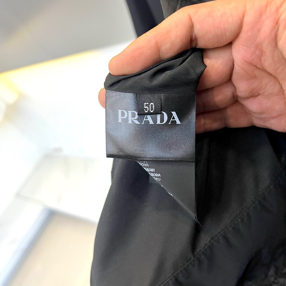 Prad普拉达、2026春夏男士夹克，以简约线条重塑都市机能美学。款式采用衬衫式翻领与利落宽松剪裁，门襟