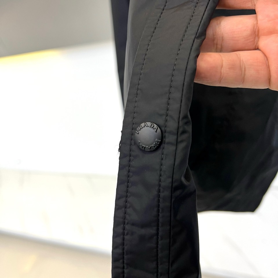 Prad普拉达、2026春夏男士夹克，以简约线条重塑都市机能美学。款式采用衬衫式翻领与利落宽松剪裁，门襟