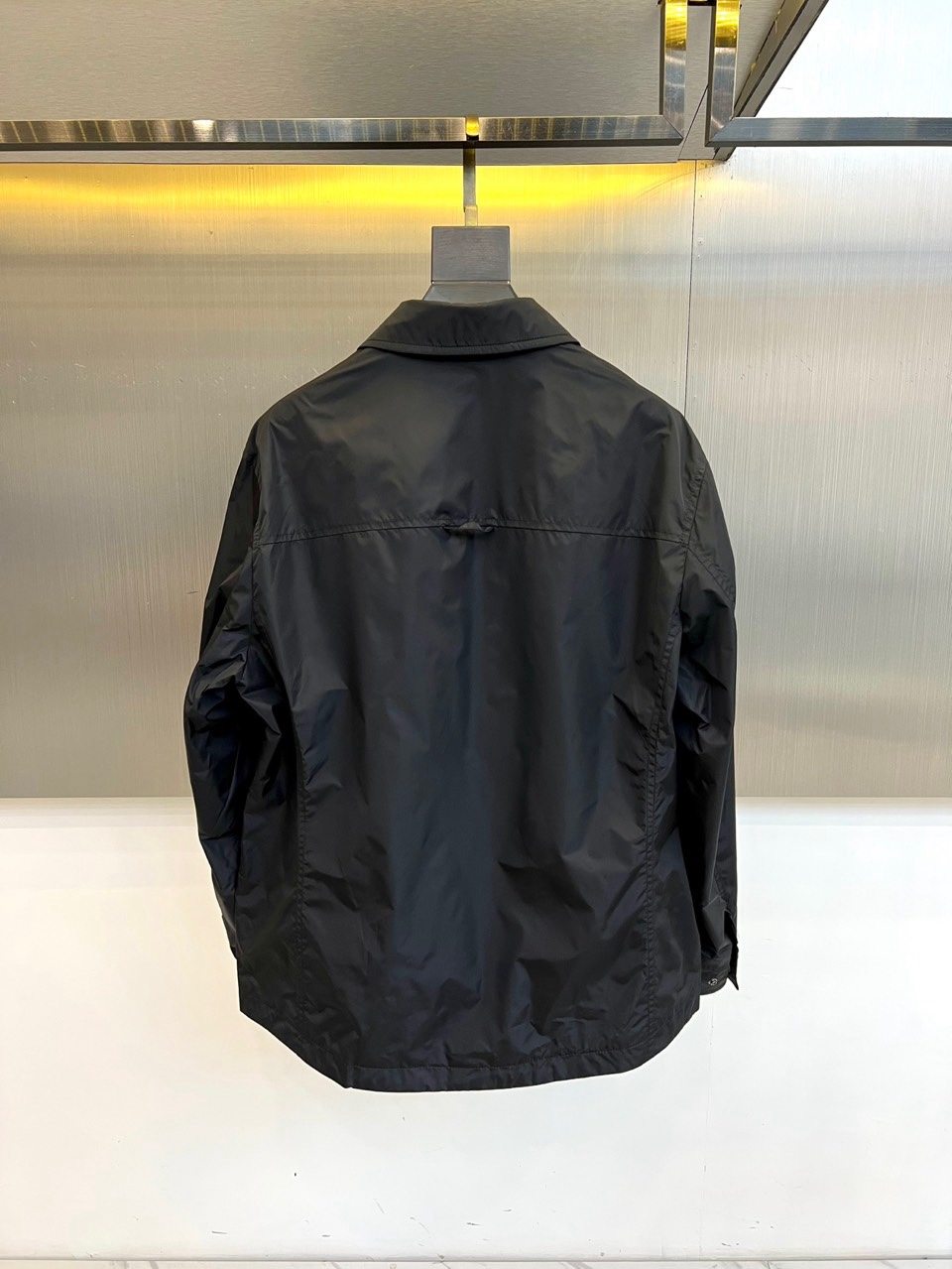 Prad普拉达、2026春夏男士夹克，以简约线条重塑都市机能美学。款式采用衬衫式翻领与利落宽松剪裁，门襟