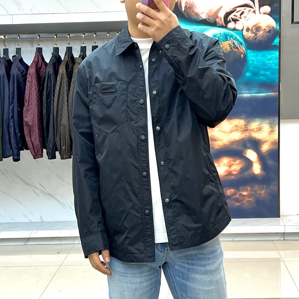 Prad普拉达、2026春夏男士夹克，以简约线条重塑都市机能美学。款式采用衬衫式翻领与利落宽松剪裁，门襟