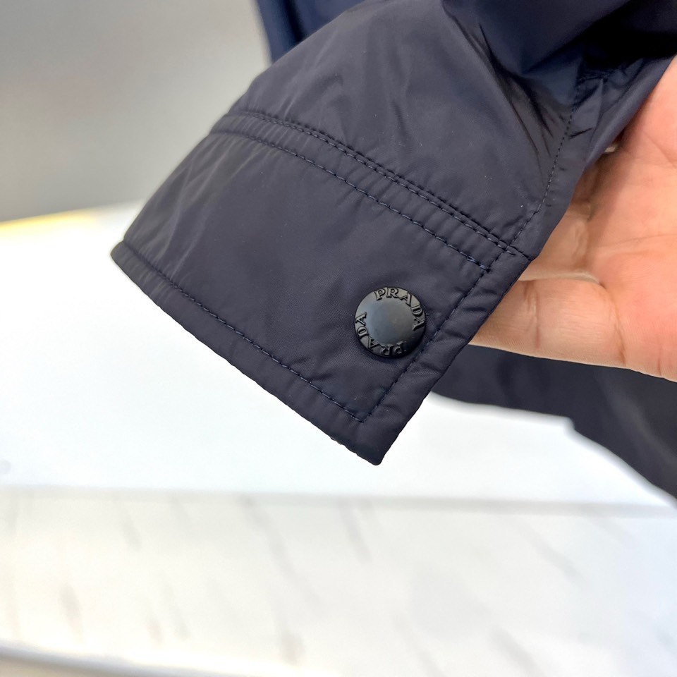 Prad普拉达、2026春夏男士夹克，以简约线条重塑都市机能美学。款式采用衬衫式翻领与利落宽松剪裁，门襟