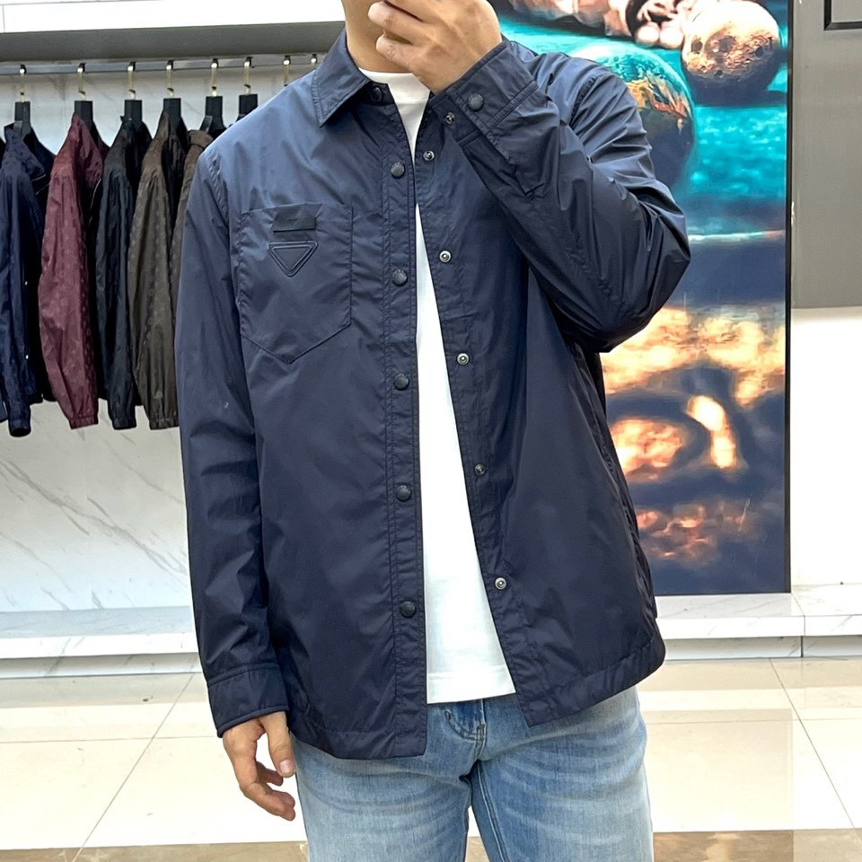 Prad普拉达、2026春夏男士夹克，以简约线条重塑都市机能美学。款式采用衬衫式翻领与利落宽松剪裁，门襟