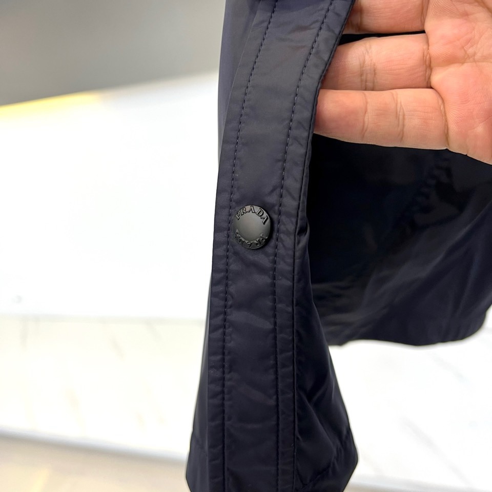 Prad普拉达、2026春夏男士夹克，以简约线条重塑都市机能美学。款式采用衬衫式翻领与利落宽松剪裁，门襟