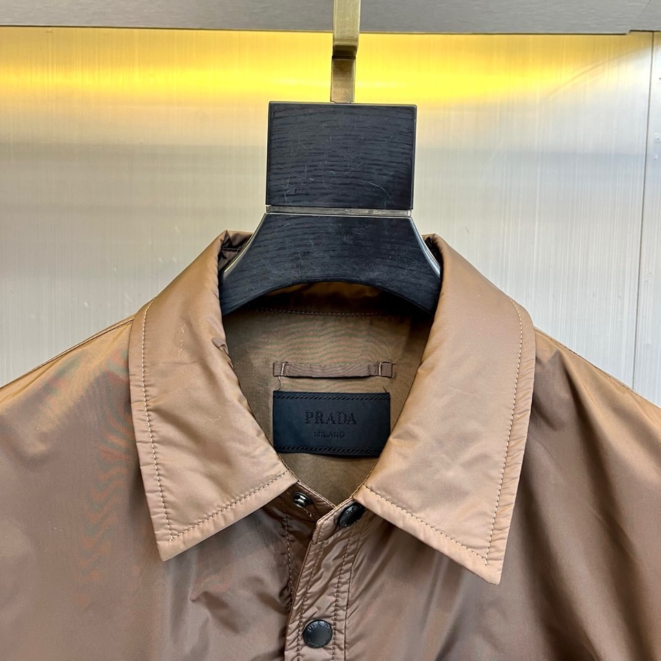 Prad普拉达、2026春夏男士夹克，以简约线条重塑都市机能美学。款式采用衬衫式翻领与利落宽松剪裁，门襟