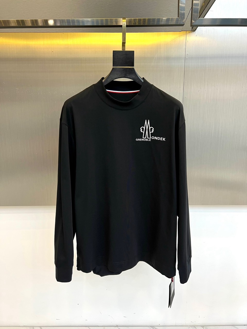 Mon蒙口、2026春夏新品长袖T恤，以经典圆领与利落长袖剪裁，诠释都市休闲风尚。其设计亮点在于领口处精