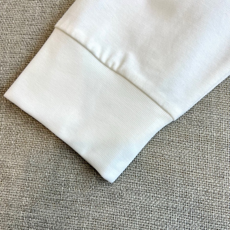 Mon蒙口、2026春夏新品长袖T恤，以经典圆领与利落长袖剪裁，诠释都市休闲风尚。其设计亮点在于领口处精