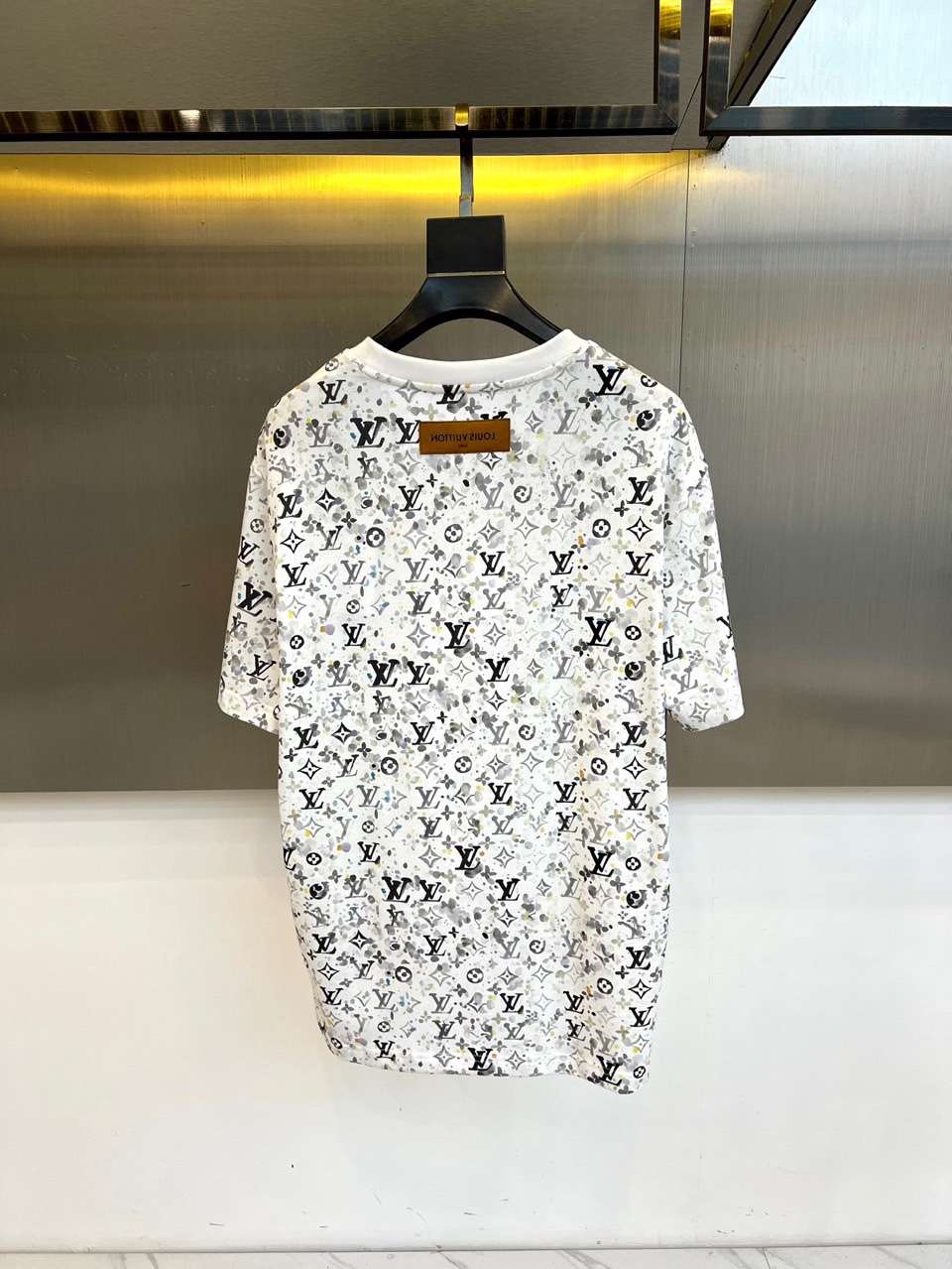 1v威登、2026春夏系列男士T恤，以宽松圆领廓形焕新经典。衣身满印品牌标志性字母组合图案，通过规律且密