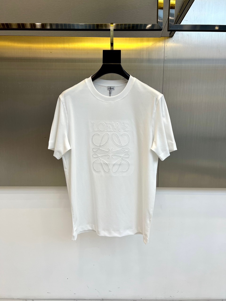 Lowe罗意威、2026春夏T恤，以经典圆领短袖廓形呈现，奠定轻松随性的基调。其设计精髓在于胸前标志性的