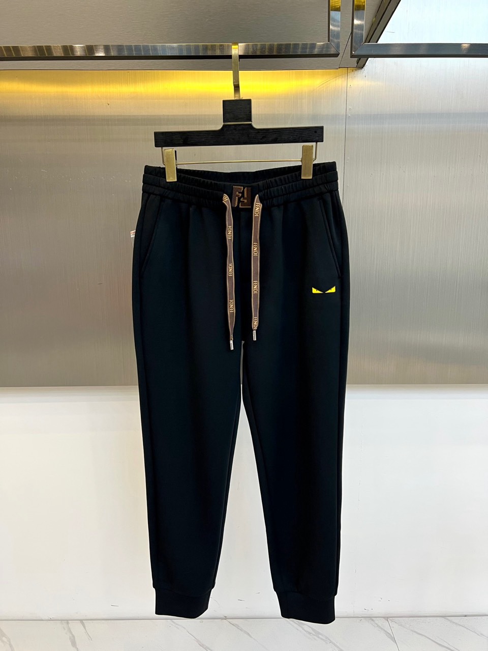 Fend芬迪、2026春夏男士休闲裤，以宽松剪裁重塑当代休闲美学。标志性设计在于裤身侧面的趣味小怪兽图案