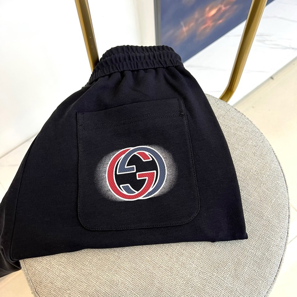 Gucc古驰、2026春夏男士休闲裤，以宽松剪裁重塑当代休闲美学。标志性设计在于裤身正面醒目的品牌刺绣标