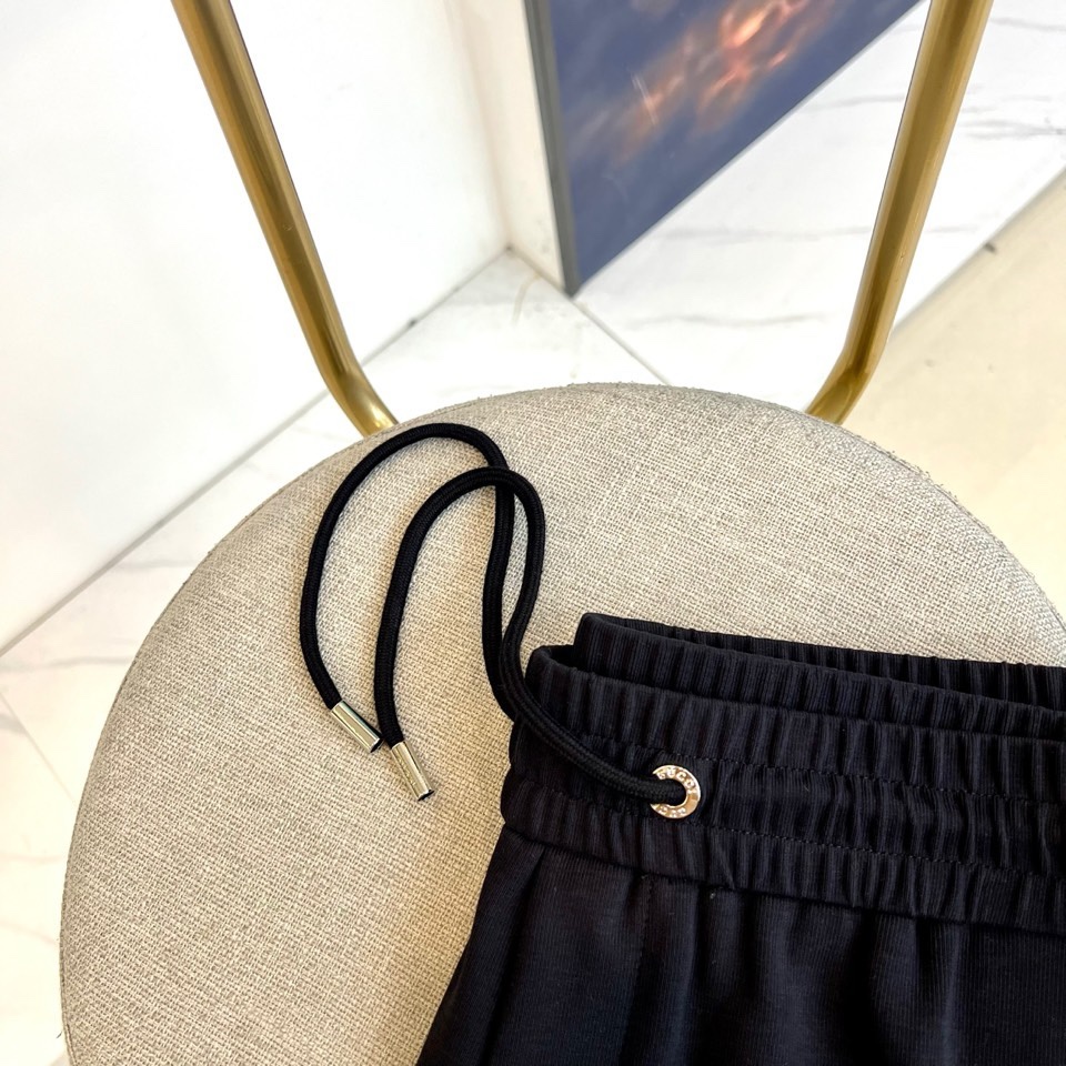 Gucc古驰、2026春夏男士休闲裤，以宽松剪裁重塑当代休闲美学。标志性设计在于裤身正面醒目的品牌刺绣标