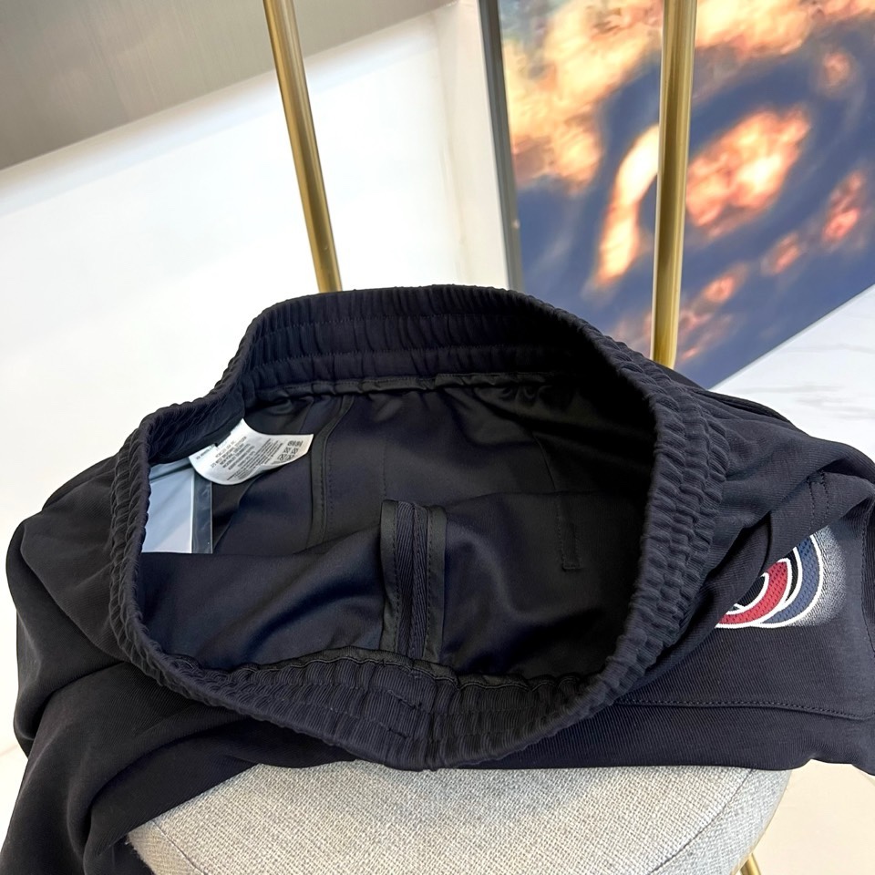 Gucc古驰、2026春夏男士休闲裤，以宽松剪裁重塑当代休闲美学。标志性设计在于裤身正面醒目的品牌刺绣标