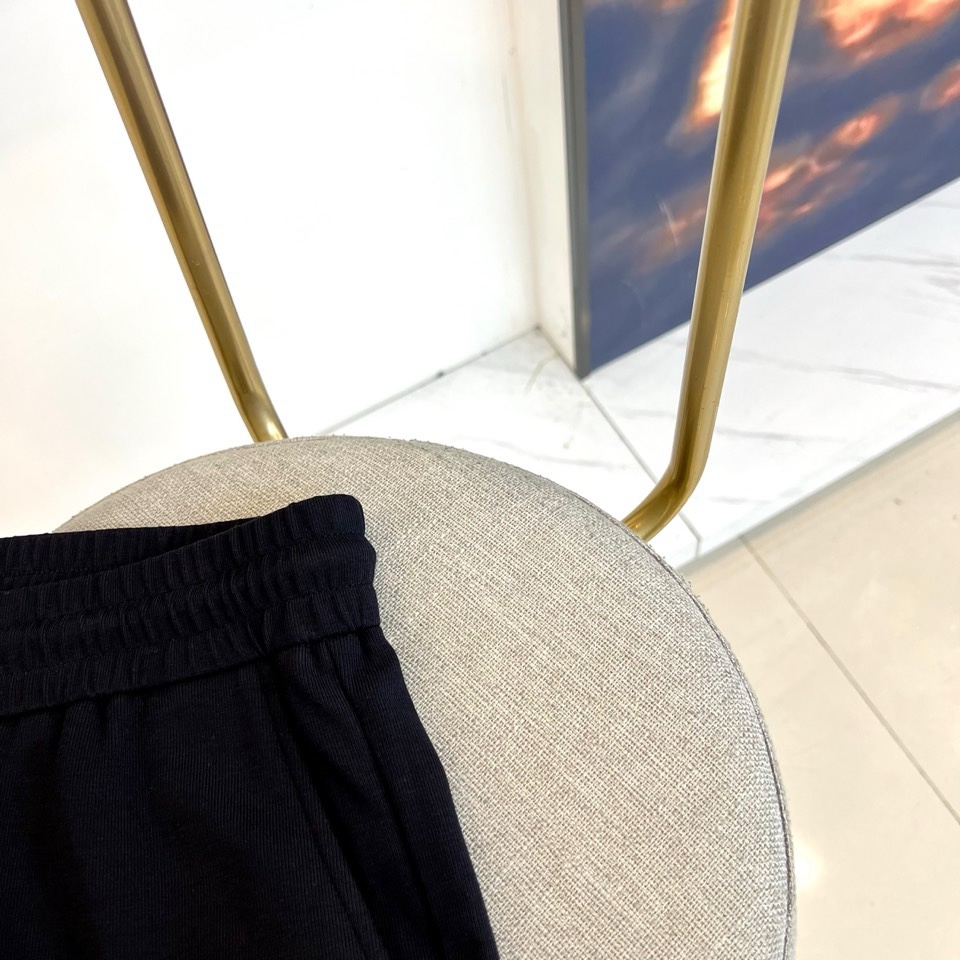 Gucc古驰、2026春夏男士休闲裤，以宽松剪裁重塑当代休闲美学。标志性设计在于裤身正面醒目的品牌刺绣标