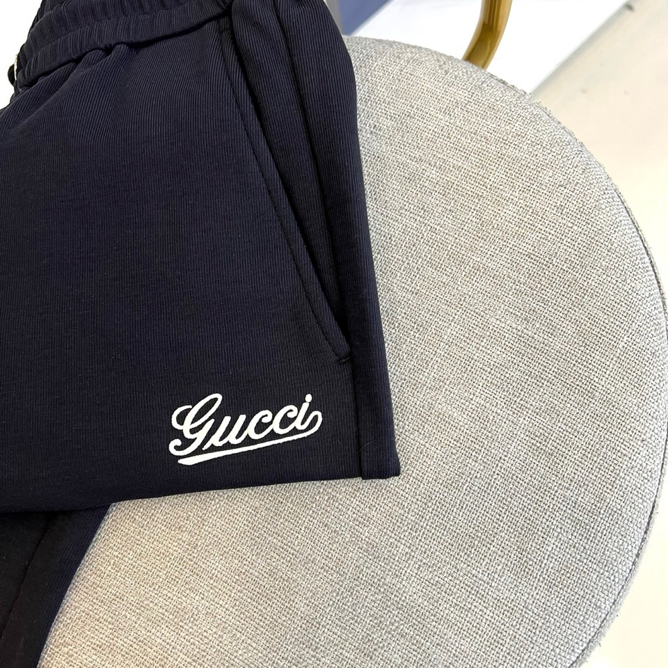 Gucc古驰、2026春夏男士休闲裤，以宽松剪裁重塑当代休闲美学。标志性设计在于裤身正面醒目的品牌刺绣标