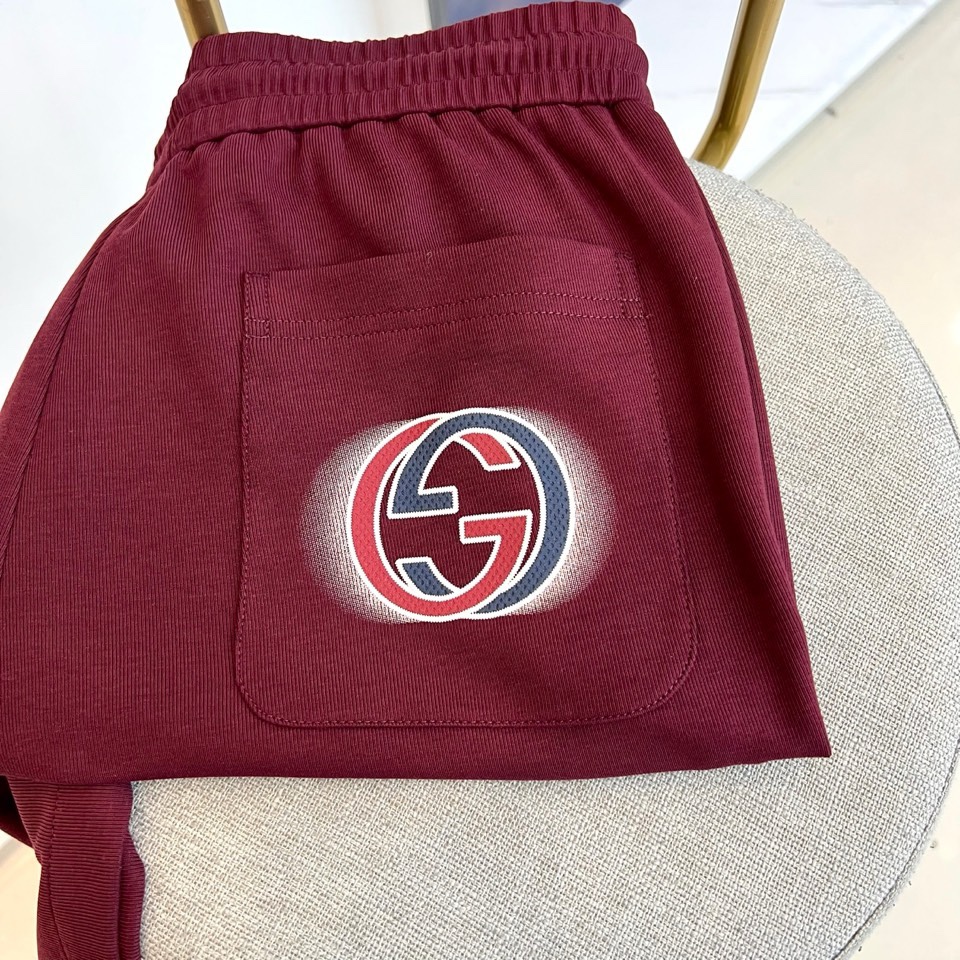 Gucc古驰、2026春夏男士休闲裤，以宽松剪裁重塑当代休闲美学。标志性设计在于裤身正面醒目的品牌刺绣标