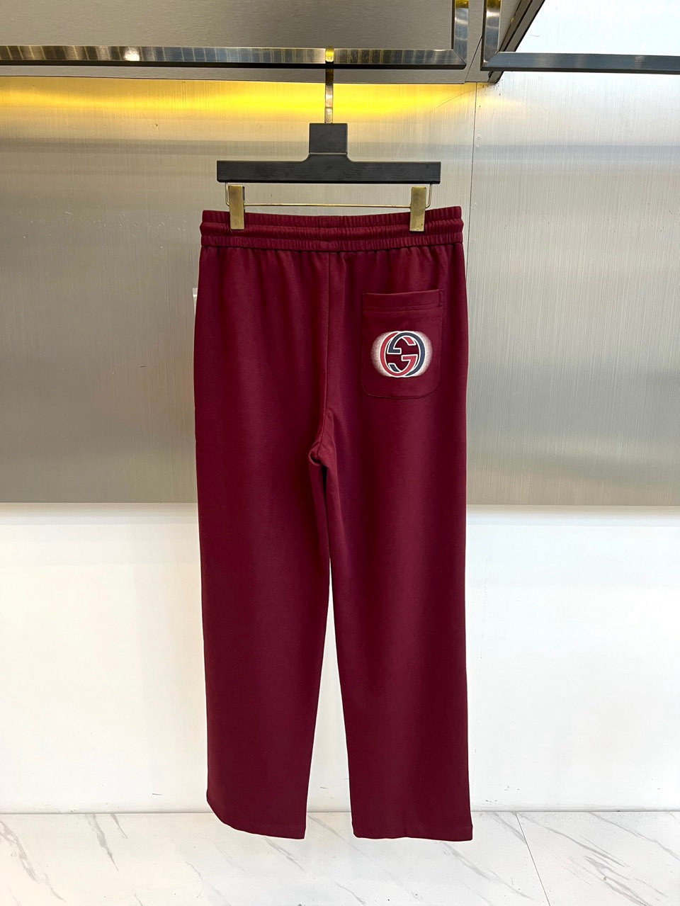 Gucc古驰、2026春夏男士休闲裤，以宽松剪裁重塑当代休闲美学。标志性设计在于裤身正面醒目的品牌刺绣标