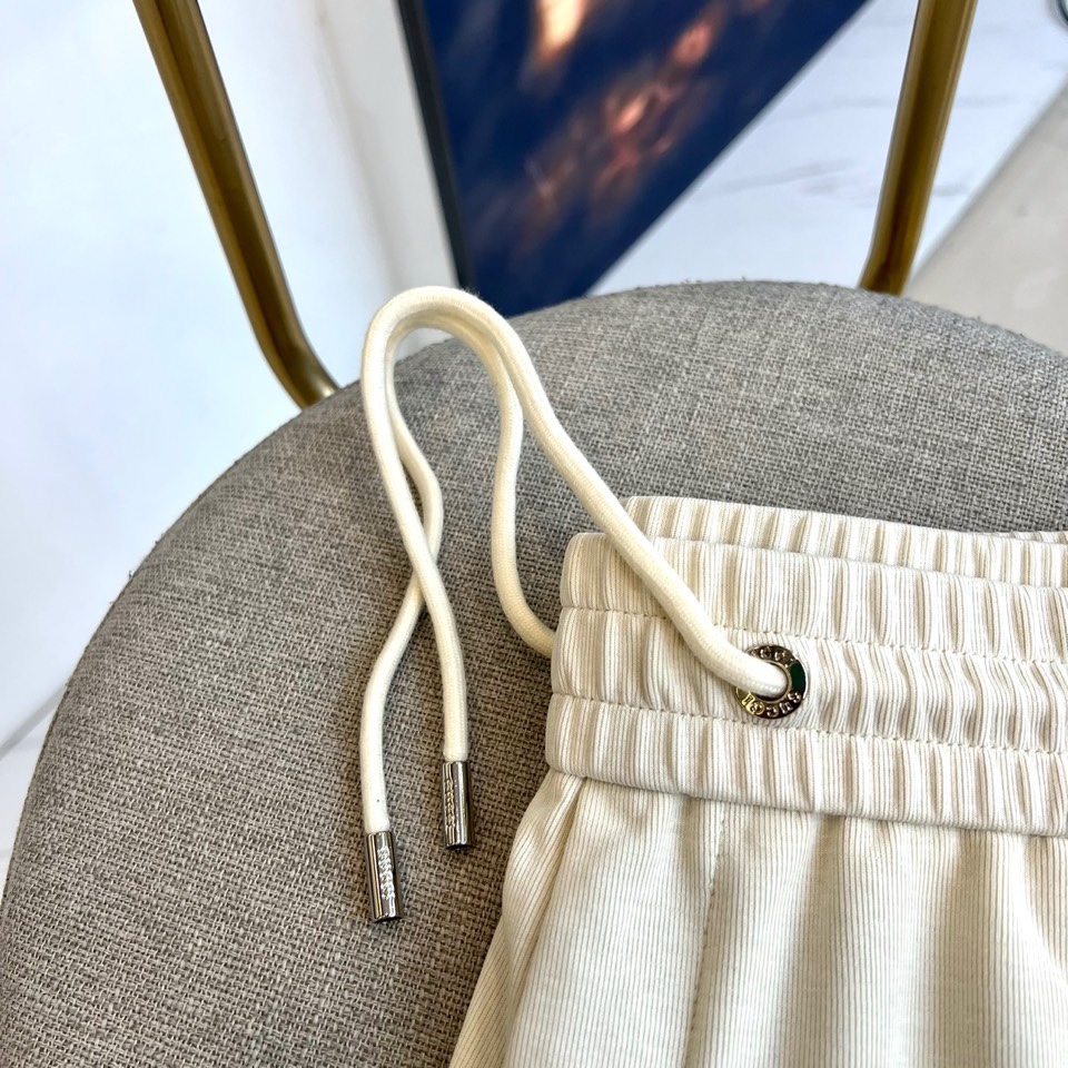 Gucc古驰、2026春夏男士休闲裤，以宽松剪裁重塑当代休闲美学。标志性设计在于裤身正面醒目的品牌刺绣标